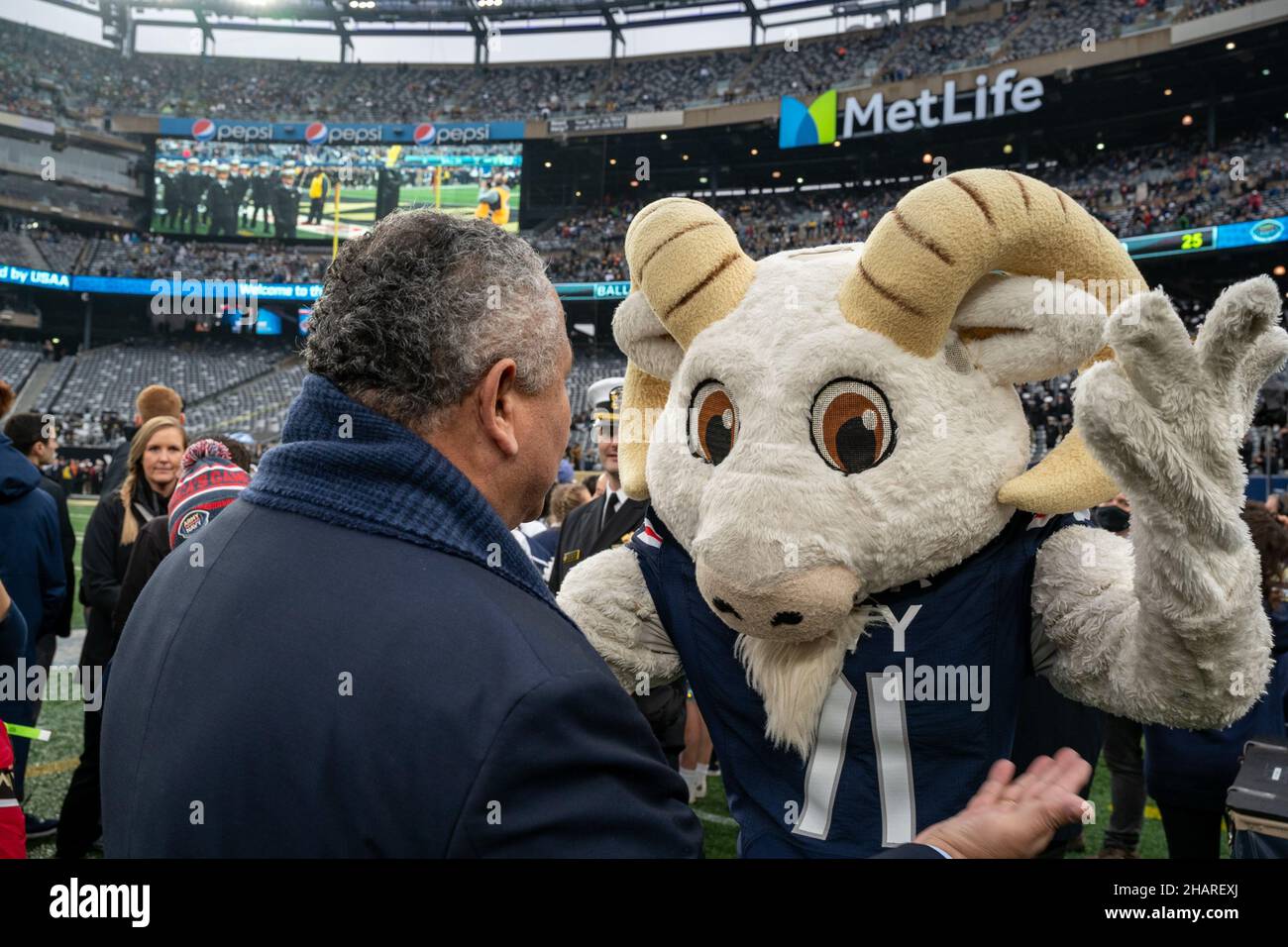 East Rutherford, Vereinigte Staaten von Amerika. 11. Dezember 2021. Der US-Navy-Sekretär Carlos Del Toro jubelt mit dem kostümierten Maskottchen Bill the Goat von der Naval Academy während des Starts des jährlichen Army-Navy-Fußballspiels im Metlife Stadium am 11. Dezember 2021 in East Rutherford, New Jersey. Die Midshipmen der U.S. Naval Academy besiegten die Army Black Knights 17-13 in ihrem Matchup von 122nd. Kredit: MC2 Logan Keown/U.S. Navy Photo/Alamy Live News Stockfoto