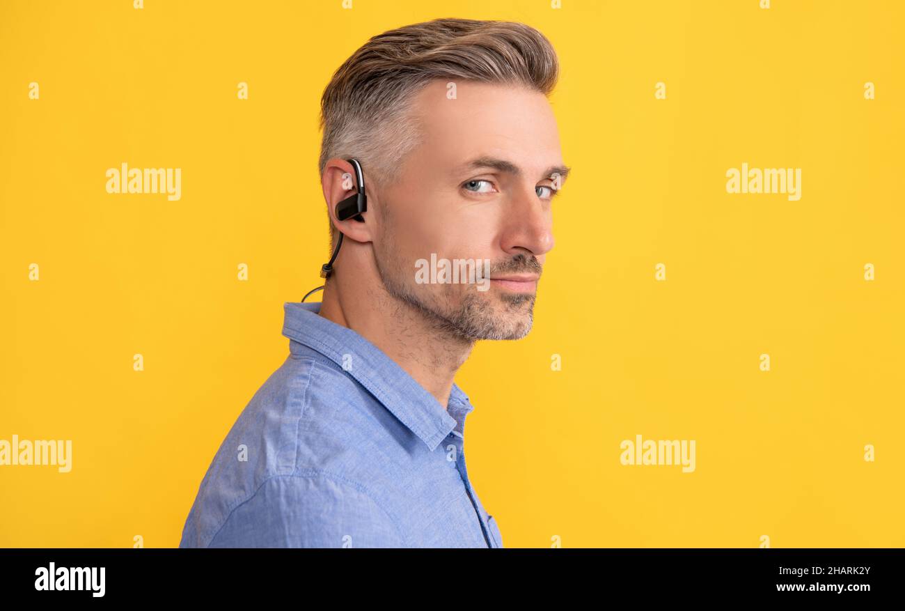 Reifer unrasiert Kerl. Agiles Geschäft. Schöner Mann mit kabellosen Kopfhörern. Stockfoto