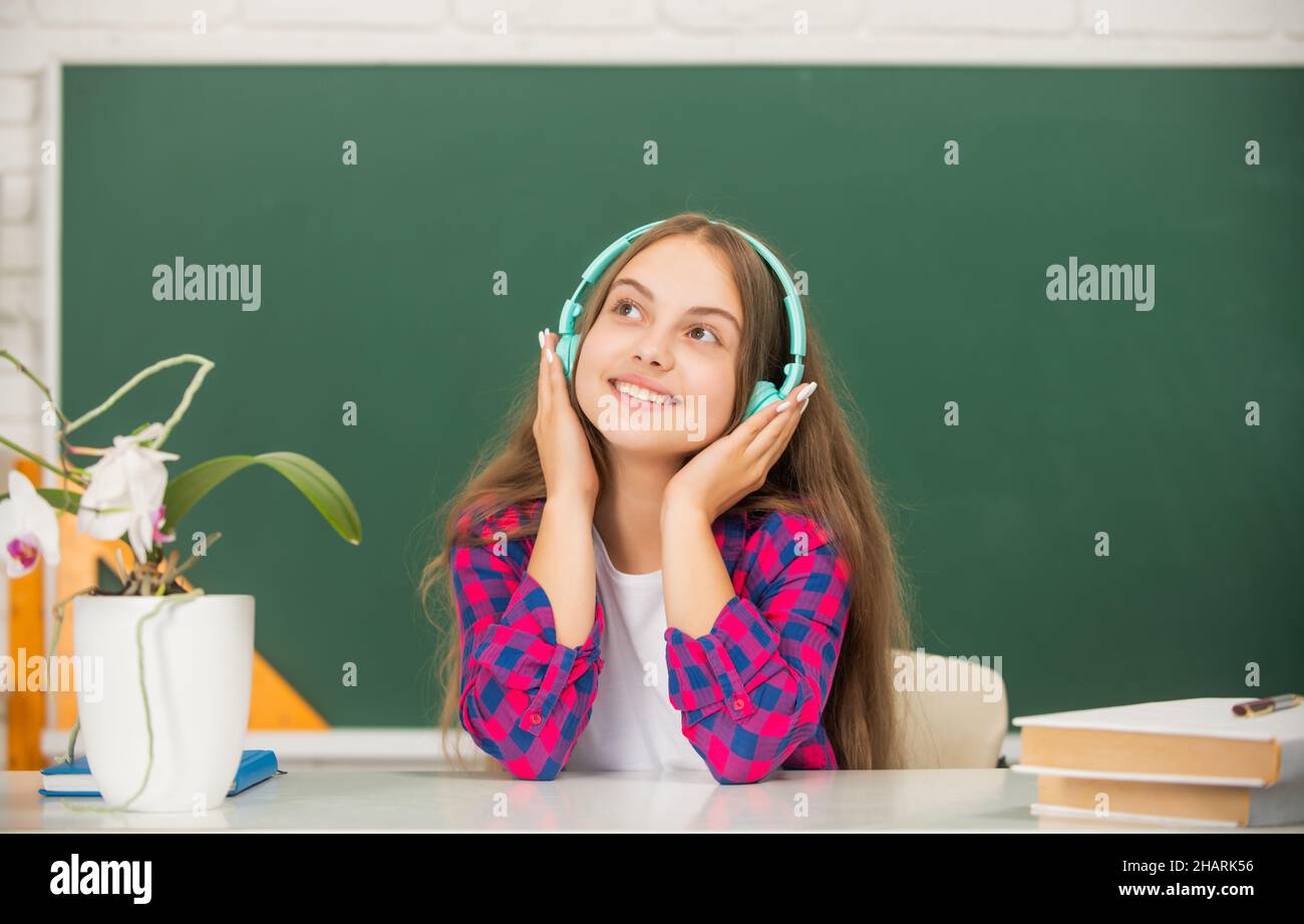 Lächelndes Kind in modernen Kopfhörern. Online-Bildung. Zurück zur Schule. Jugendliches Mädchen in Kopfhörern. Stockfoto