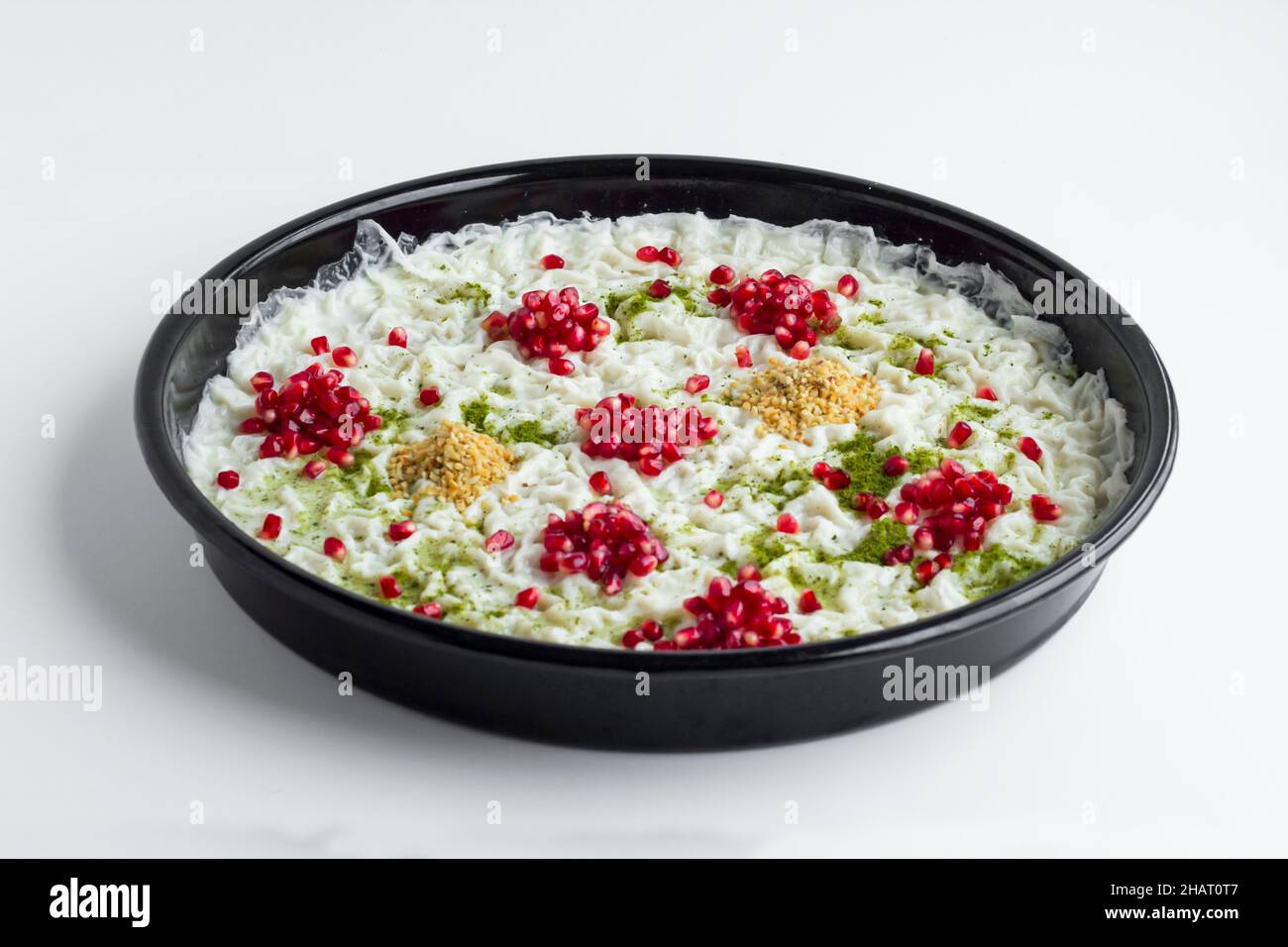 Traditionelles Ramadan Dessert Gullac auf einem Tablett, das mit Granatapfelkernen, Pistazien und gehackten Haselnüssen verziert ist.Es ist ein sehr altes Dessert aus dem Osmanischen Reich Stockfoto