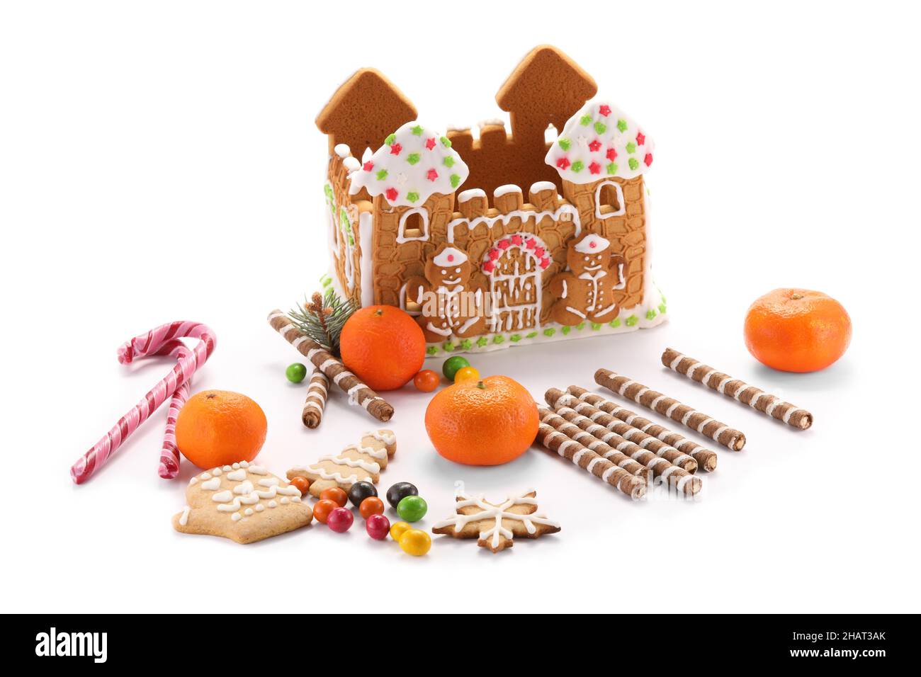 Lebkuchenhaus, Mandarinen und Leckereien isoliert auf weißem Hintergrund Stockfoto