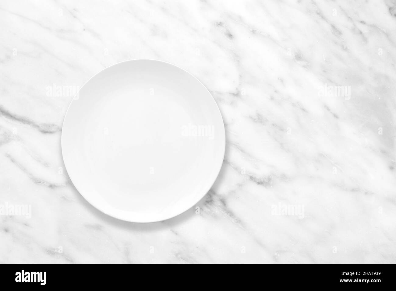 Weißer Teller auf Marmorsteintisch, Plattenmockup, Draufsicht Stockfoto