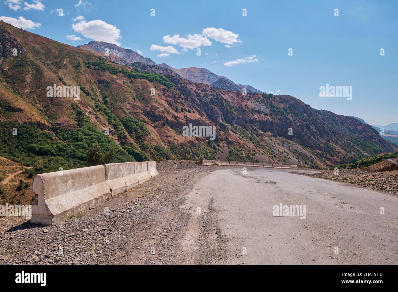 Weiße Betonbarrieren an einer gefährlichen Kurve in der Straße. Im Gebiet des Charvak-Sees in der Nähe von Taschkent, Usbekistan. Stockfoto
