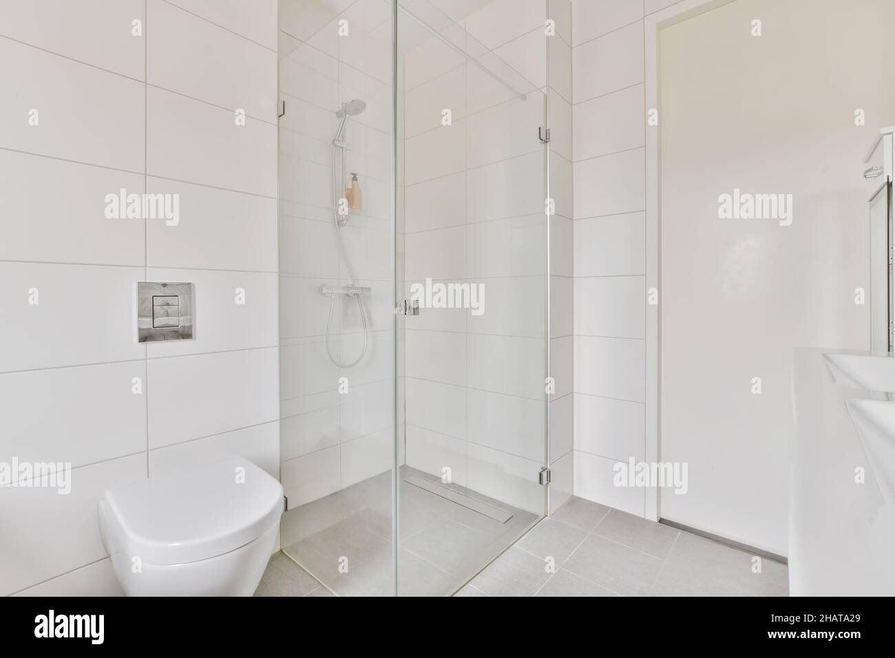 Luxuriöses Badezimmer mit weißen Fliesen und hängender Toilette Stockfoto