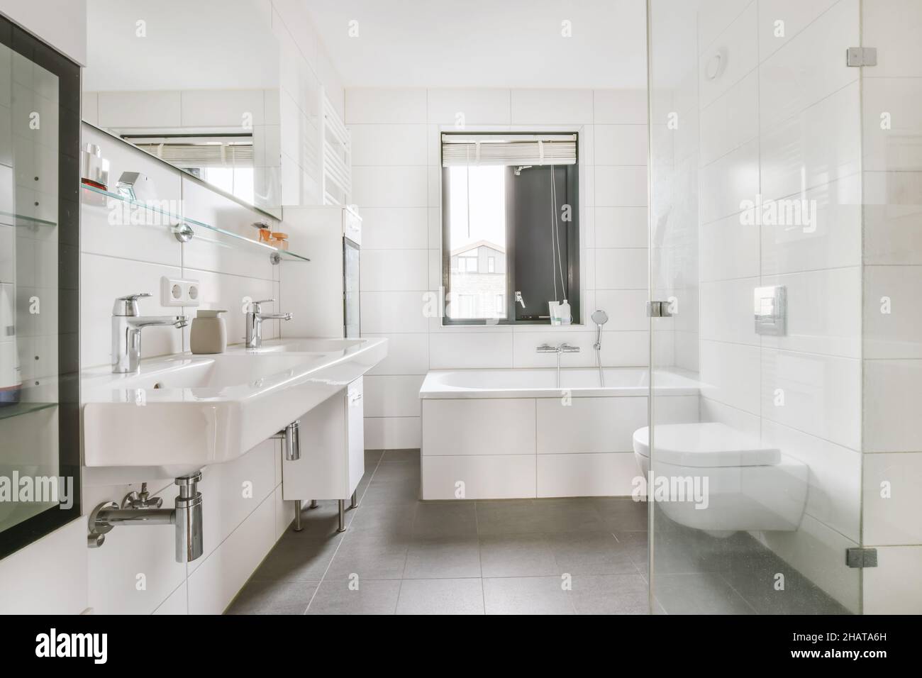 Luxuriöses Badezimmer mit weißen Fliesen und hängender Toilette Stockfoto