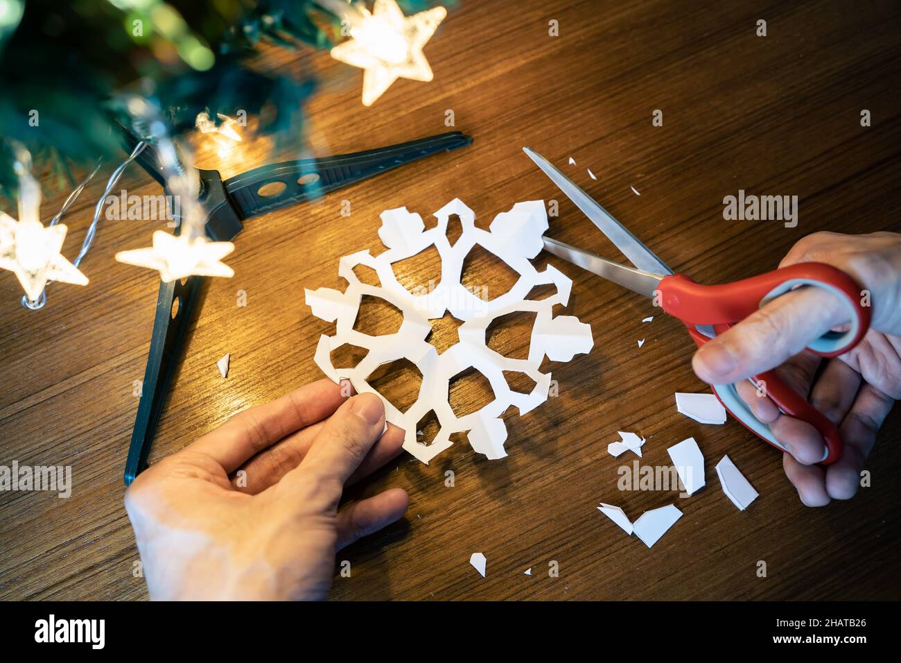 Schneiden der Schneeflockenform aus einem Papier Stockfoto