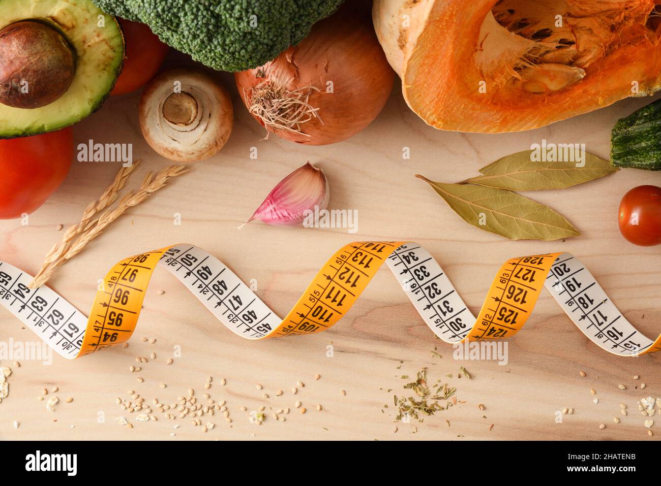 Gewichtskontrolle Konzept mit Maßband und Lebensmittel auf Holztisch voll mit gesunden Lebensmitteln. Draufsicht. Horizontale Zusammensetzung. Stockfoto