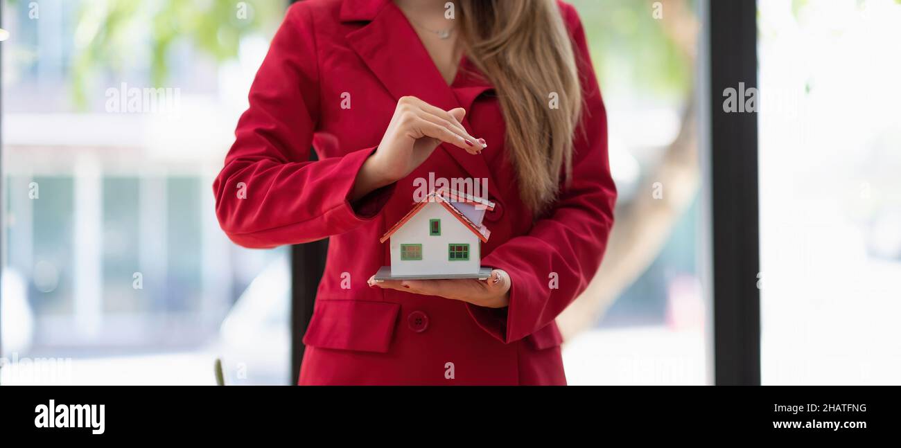 Hände Frau schützen Holzhaus Modell. Hausversicherungskonzept Stockfoto Hände Frau schützen Holzhaus Modell. Hausversicherungskonzept Stockfoto