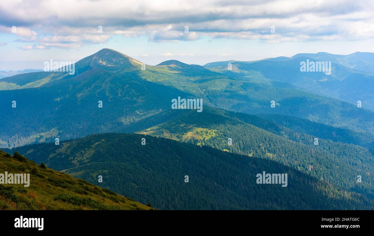 Bergige Naturlandschaft im Sommer. Szenische Reise im Freien Hintergrund. Blick in die ferne Chernohora Kamm mit Hoverla Gipfel und Wolken auf der Stockfoto