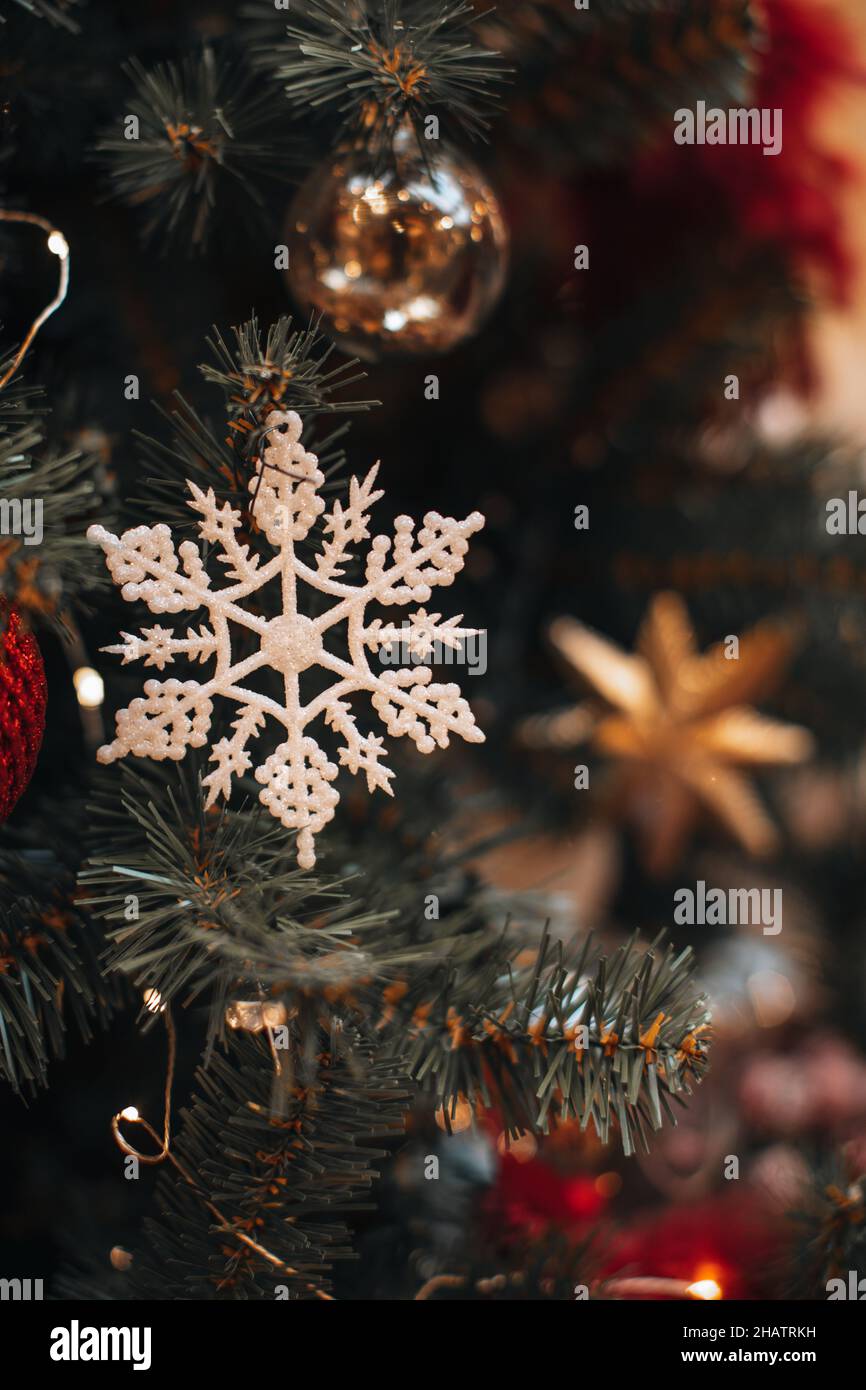 Silberne weiße Weihnachts-Schneeflocke, die auf dem Weihnachtsbaum hängt. Magische Details. Details zu Winterferien Stockfoto