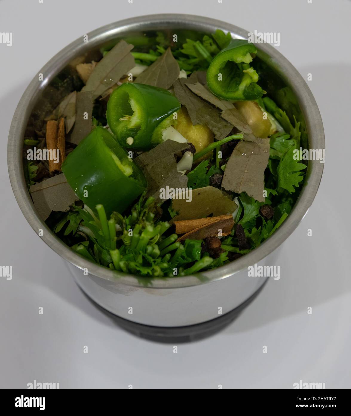 Eine Mischung aus Kräutern, Gemüse und Gewürzen, gefüllt in einem Mixbecher, fertig gemahlen. Stockfoto