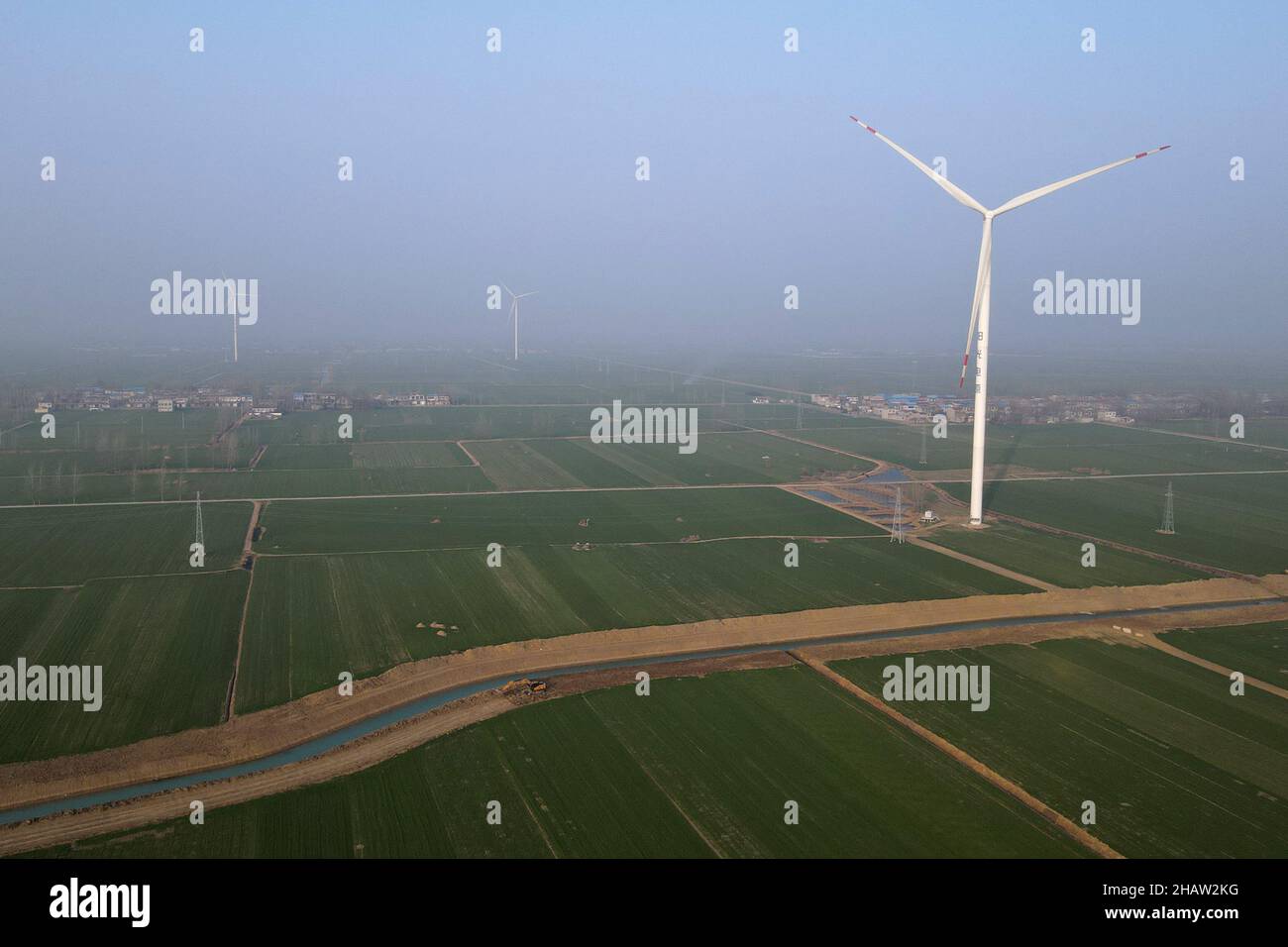 (211215) -- HEFEI, 15. Dezember 2021 (Xinhua) -- Luftfoto vom 14. Dezember 2021 zeigt Windturbinen im Hexin-Windkraftwerk in Bozhou, der ostchinesischen Provinz Anhui. Im Vergleich zu herkömmlichen Windparks ist das Windkraftwerk Hexin Bozhou mit Energiespeichern mit einer Kapazität von 10 MWh ausgestattet. Es kann Strom während der Spitzenzeiten speichern und dann während der Spitzenzeiten freisetzen. Durch die Umverteilung des Stroms während der Spitzen- und Nebenzeiten trägt das „neue Energiespeichersystem“ zum stabilen Betrieb des Stromnetzes und zum neuen Energieverbrauch bei. (X Stockfoto