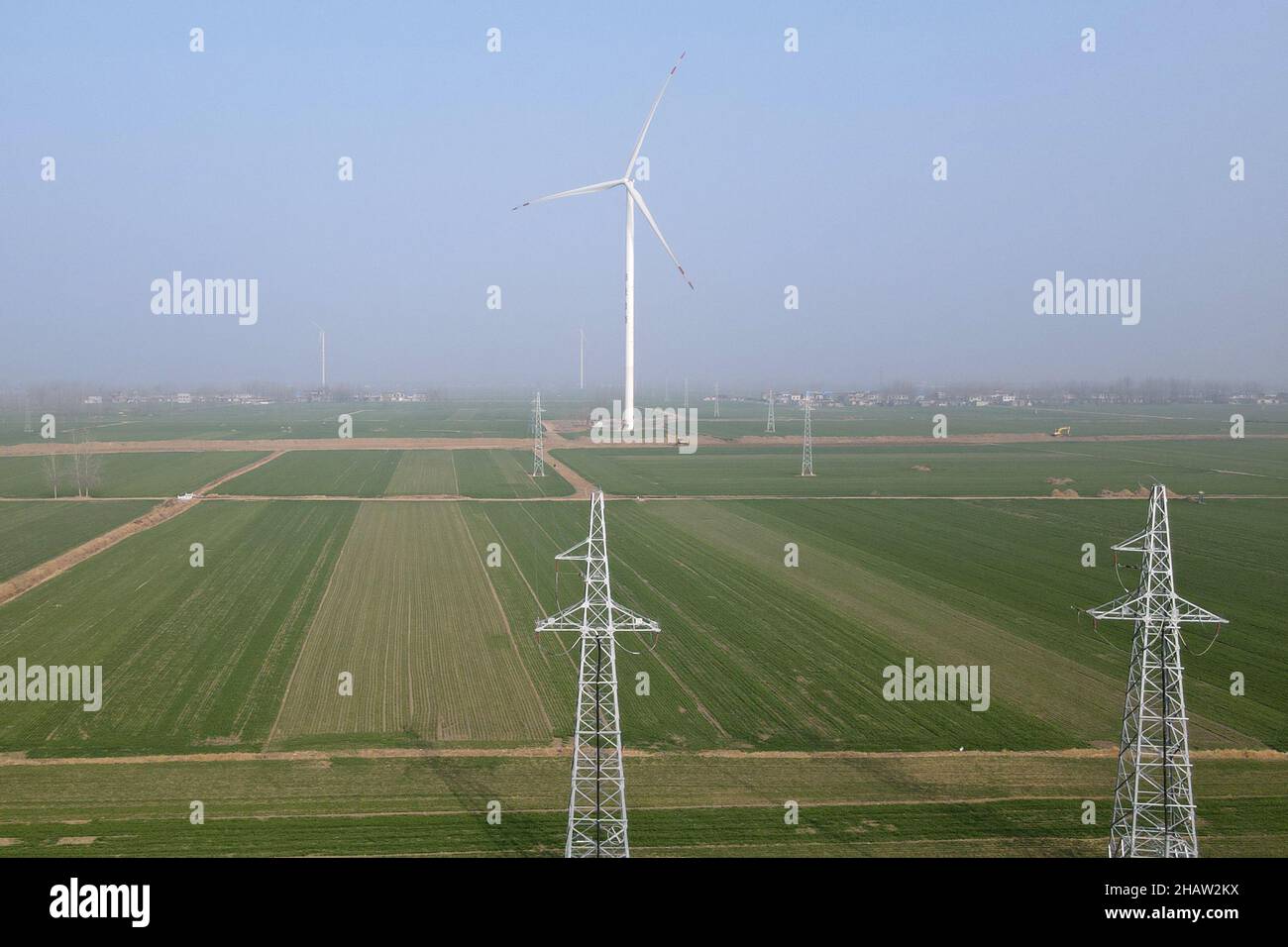 (211215) -- HEFEI, 15. Dezember 2021 (Xinhua) -- Luftfoto vom 14. Dezember 2021 zeigt Windturbinen im Hexin-Windkraftwerk in Bozhou, der ostchinesischen Provinz Anhui. Im Vergleich zu herkömmlichen Windparks ist das Windkraftwerk Hexin Bozhou mit Energiespeichern mit einer Kapazität von 10 MWh ausgestattet. Es kann Strom während der Spitzenzeiten speichern und dann während der Spitzenzeiten freisetzen. Durch die Umverteilung des Stroms während der Spitzen- und Nebenzeiten trägt das „neue Energiespeichersystem“ zum stabilen Betrieb des Stromnetzes und zum neuen Energieverbrauch bei. (X Stockfoto