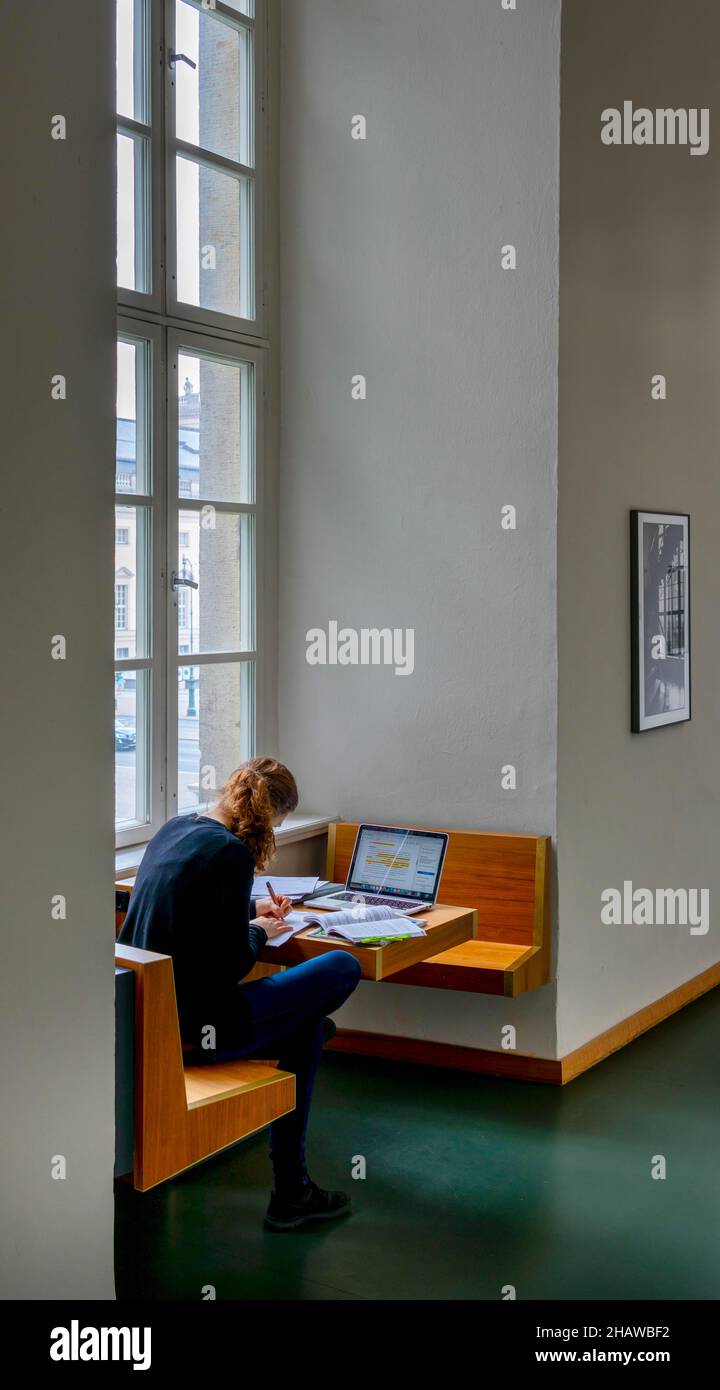 Eine Studentin sitzt mit ihrem Laptop am Fenster im Gebäude der Humboldt-Universität, Berlin Stockfoto