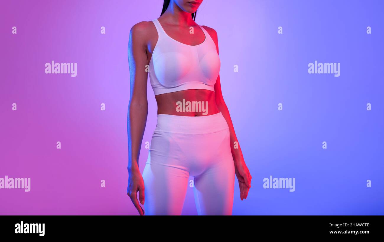 Nicht Erkennbare Fitness Lady Mit Perfektem Körper Stehend, Neonhintergrund Stockfoto