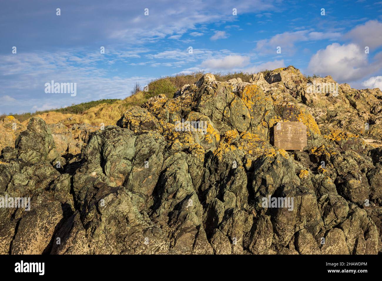 Gwnhingaer Fawr hat Stein auf die basaltischen Pillow-Lava-Felsen am Newborough Beach neben Llanddwyn Island, Isle of Anglesey, Nordwales, graviert Stockfoto