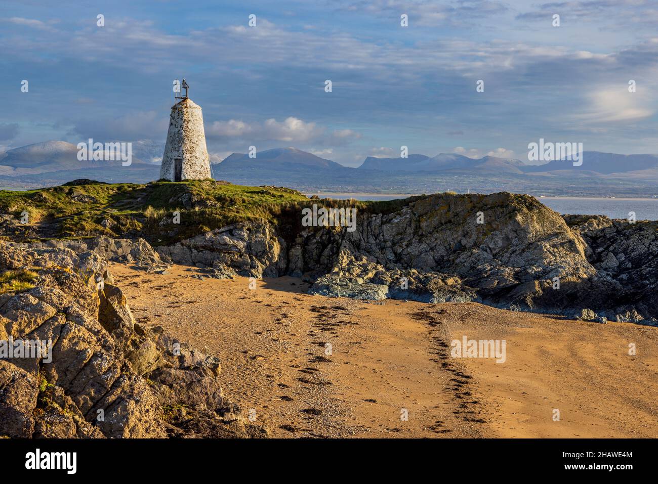 TWR Bach Leuchtturm auf Ynys Llanddwyn mit den Snowdonia Bergen im Hintergrund, Isle of Anglesey, Nordwales Stockfoto