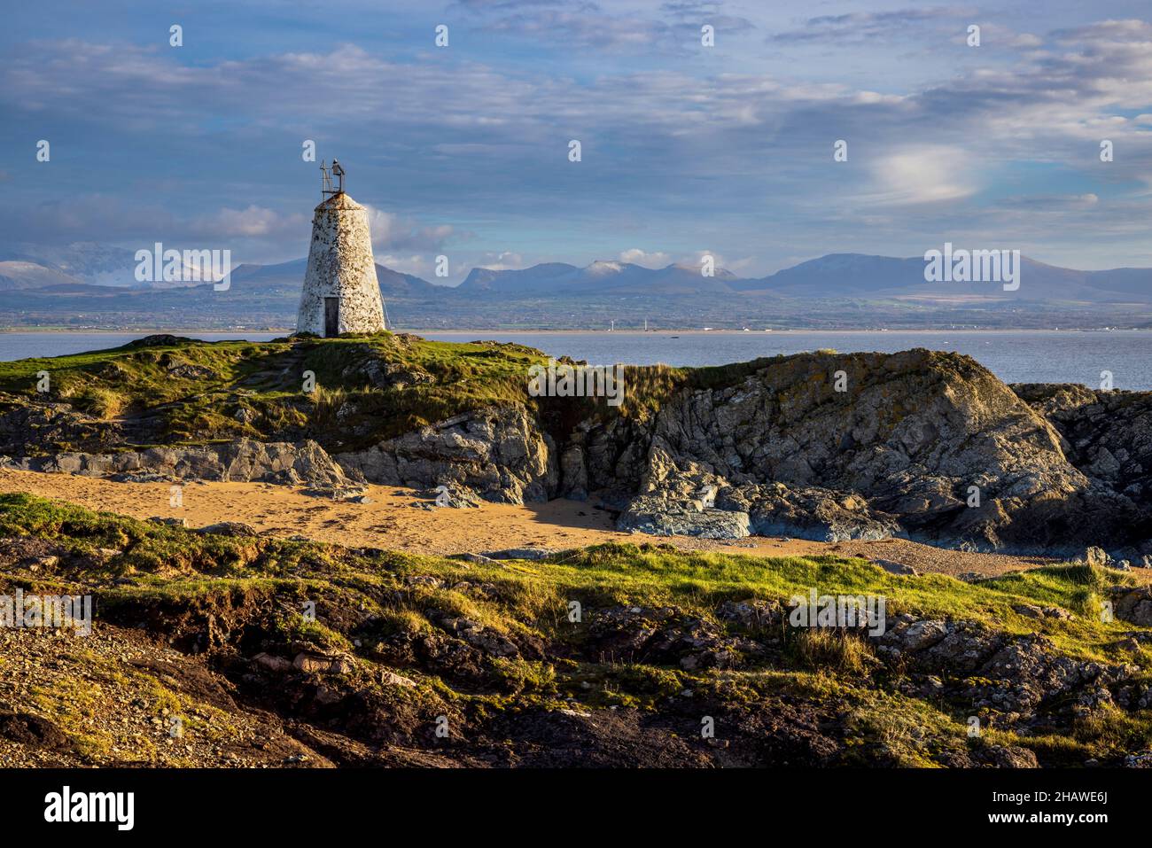 TWR Bach Leuchtturm auf Ynys Llanddwyn mit den Snowdonia Bergen im Hintergrund, Isle of Anglesey, Nordwales Stockfoto