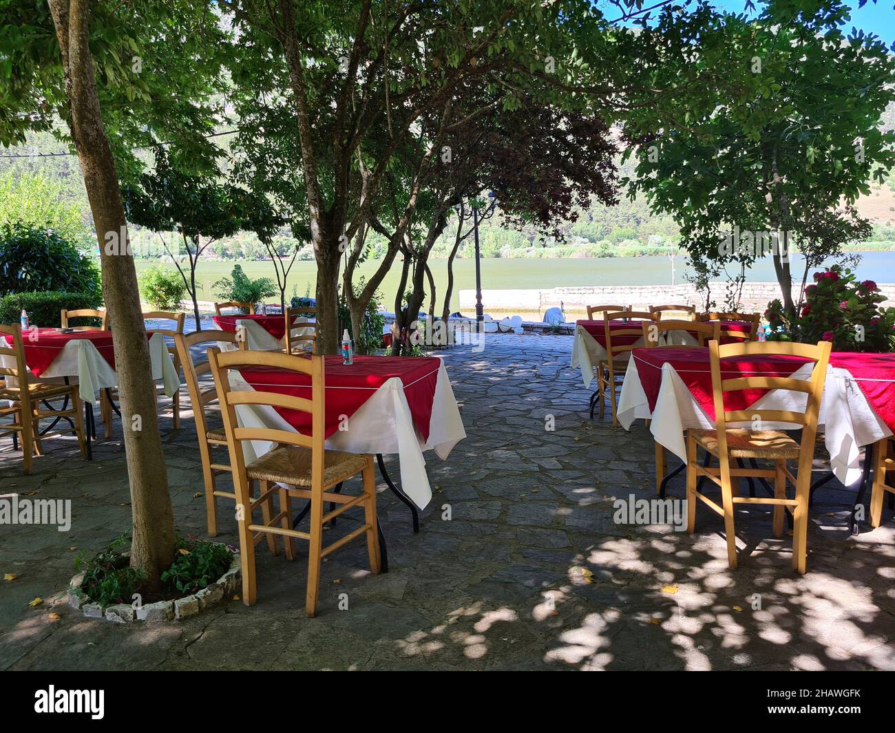 Ioannina, Griechenland - 27. Juni 2021: Tische mit Spray zur Desinfektion während der Coronapandemie im Gartenbereich eines Restaurants Stockfoto