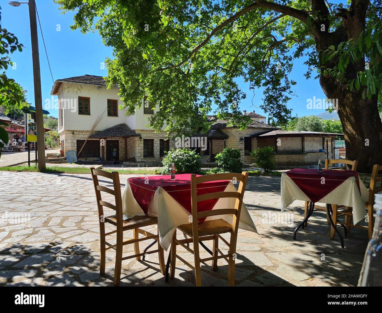 Ioannina, Griechenland - 27. Juni 2021: Tisch mit Spray zur Desinfektion während der Coronapandemie im Gartenbereich eines Restaurants Stockfoto