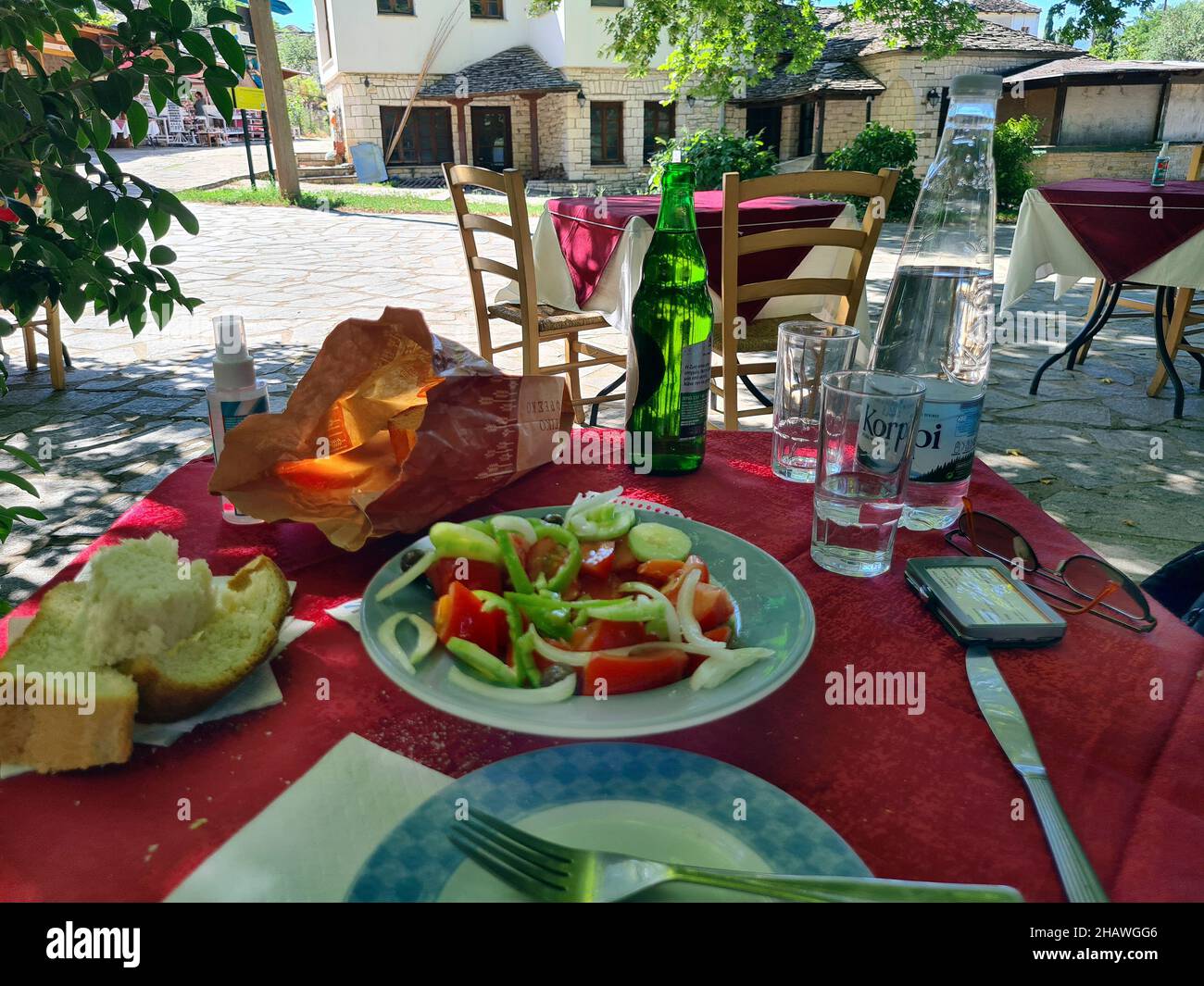 Ioannina, Griechenland - 27. Juni 2021: Tisch mit Getränken und Salat im Gartenbereich eines Restaurants auf der winzigen Insel im Pamvotida-See Stockfoto