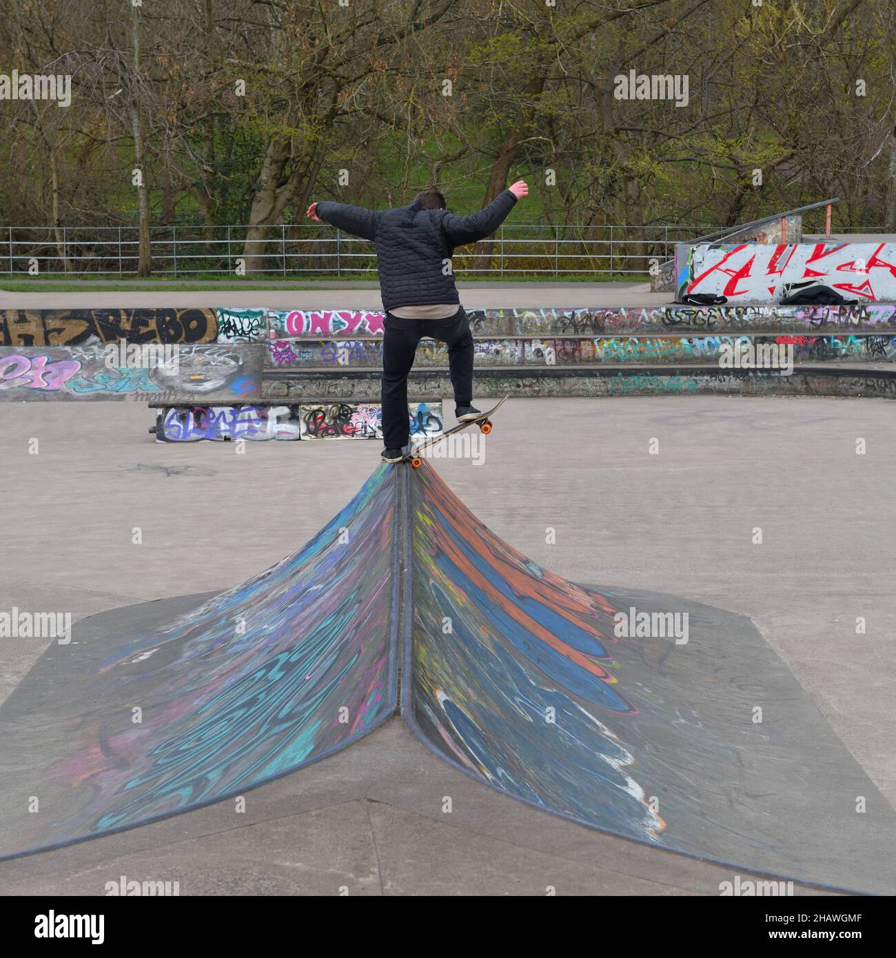 Teenager, der sein Können auf einem Skateboard im Skatepark im Kelvingrove Park, Glasgow, Schottland, Großbritannien, demonstriert Stockfoto