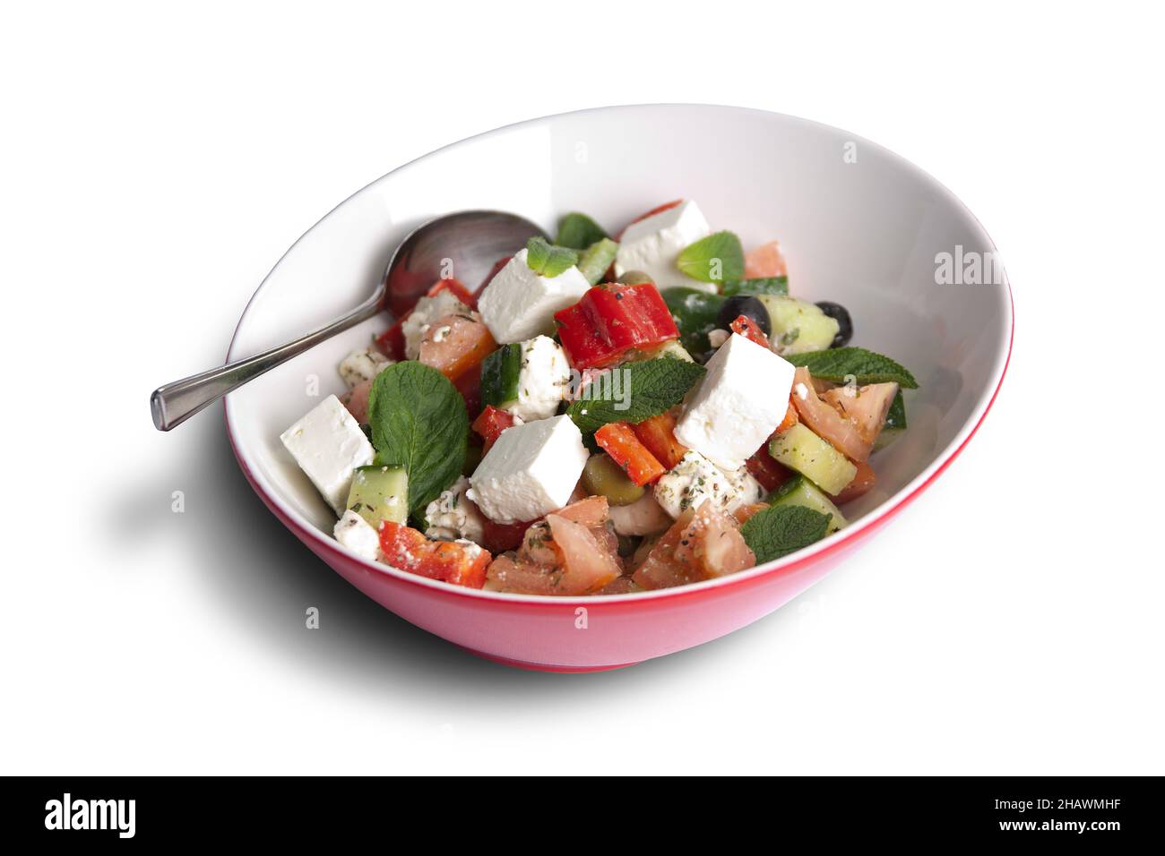 Schüssel griechischer Salat mit Löffel auf Weiß Stockfoto
