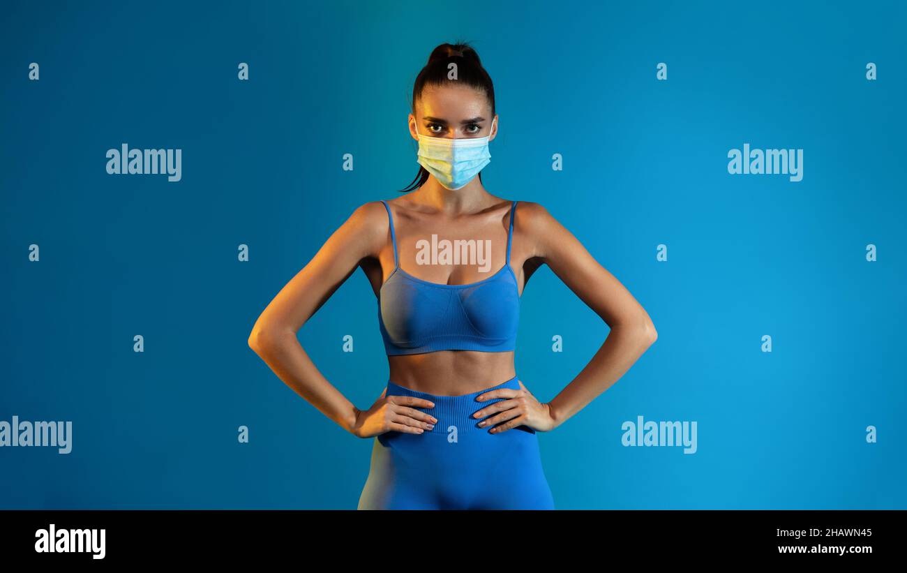Fitness Lady Trägt Gesichtsmaske Posiert Im Studio, Panorama Stockfoto