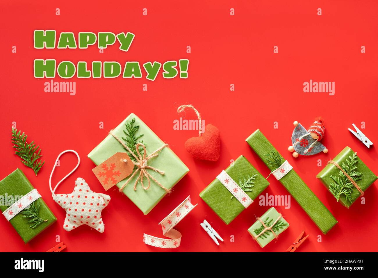 Text „Happy Holidays“. Weihnachtsgeschenke, Weihnachtsgeschenke oder Neujahrsgeschenke. Geometrische diagonale Late. Schachteln in Recyclingpapier verpackt, mit Kordel oder gebunden Stockfoto