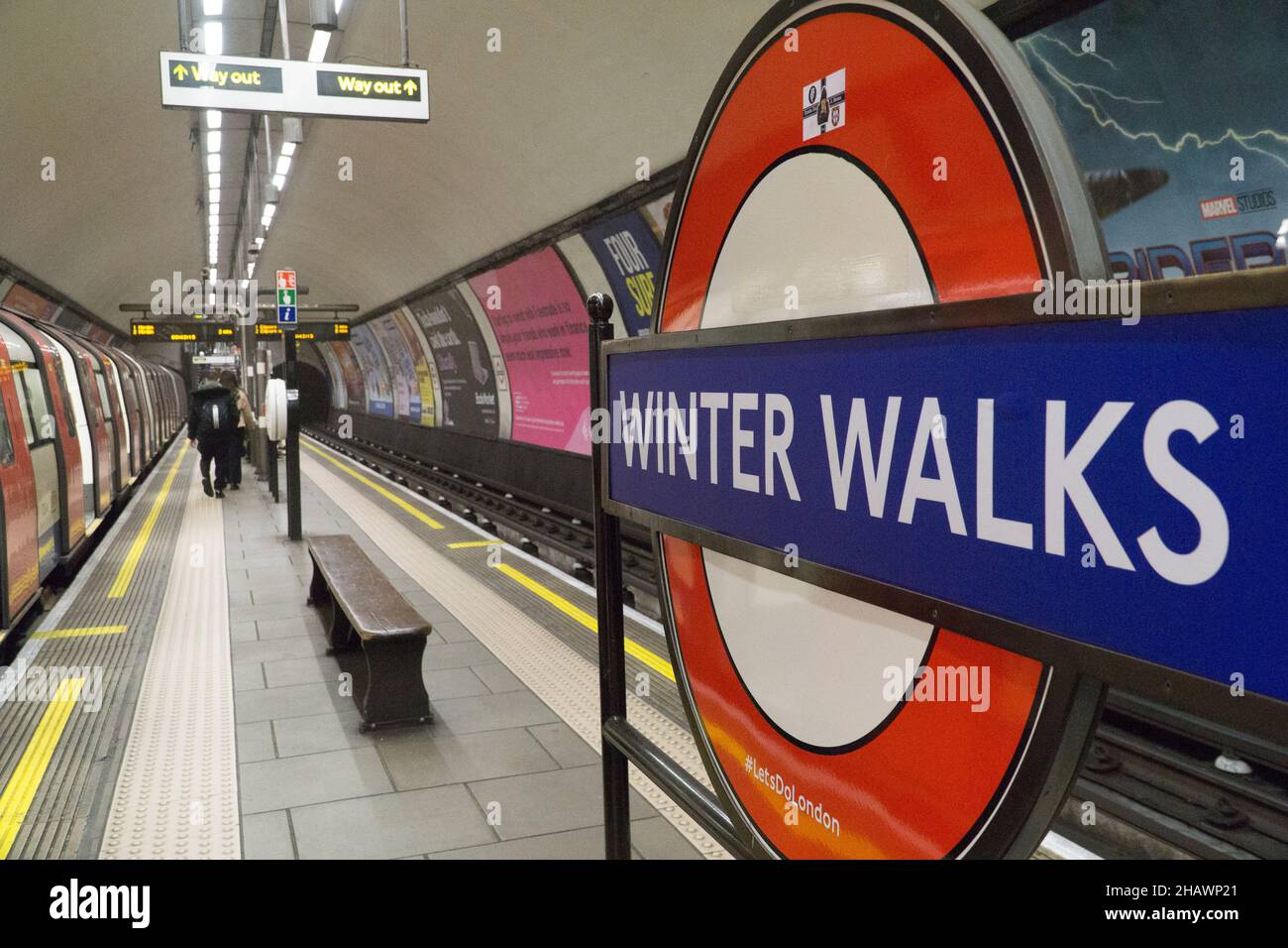 London, Großbritannien, 15. Dezember 2021: Winterwanderungen sind eine empfohlene Aktivität an der U-Bahnstation Clapham Common als Teil der Werbung für die Kampagne des Bürgermeisters #LetsDoLondon. Das übliche Rondel wurde im Rahmen einer Kampagne mit einem temporären Zeichen bedeckt, um die Menschen daran zu erinnern, dass sie immer noch in London draußen sein können. Winterwanderungen sind wahrscheinlich eine der sichersten Aktivitäten, da Menschen aufgrund der schnellen Verbreitung der omicron-Variante zunehmend dazu ermutigt werden, ihre und die Sicherheit anderer zu berücksichtigen. Anna Watson/Alamy Live News. Stockfoto