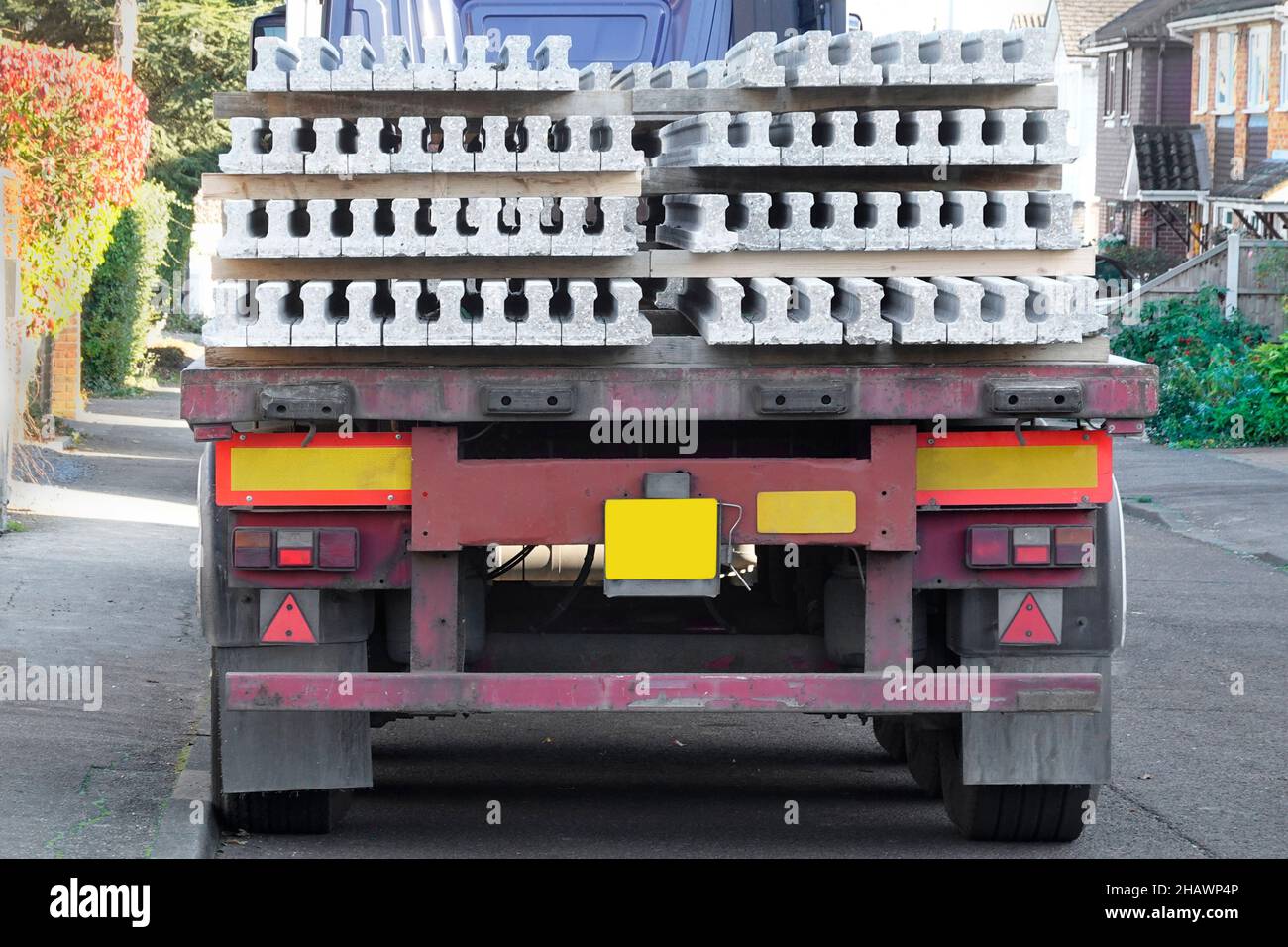 Back & End Straßenansicht der artikulierten Anhängerlieferung an die Hausbaustelle einer Ladung Betonfertigteilbodenbalken England Großbritannien Stockfoto