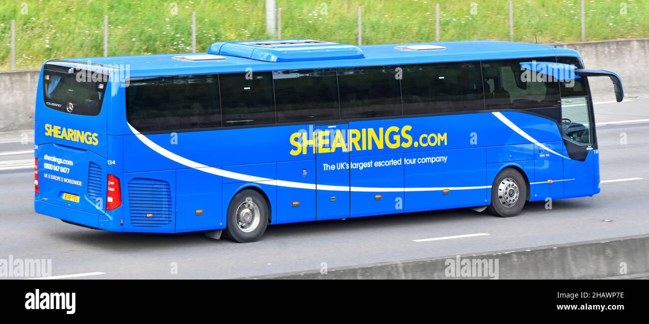 Grafisches Design auf der Seitenansicht der getönten Passagierfenster von Shearings Reiseunternehmen, Reisebus und Busreisen, die entlang der Autobahn England fahren Stockfoto