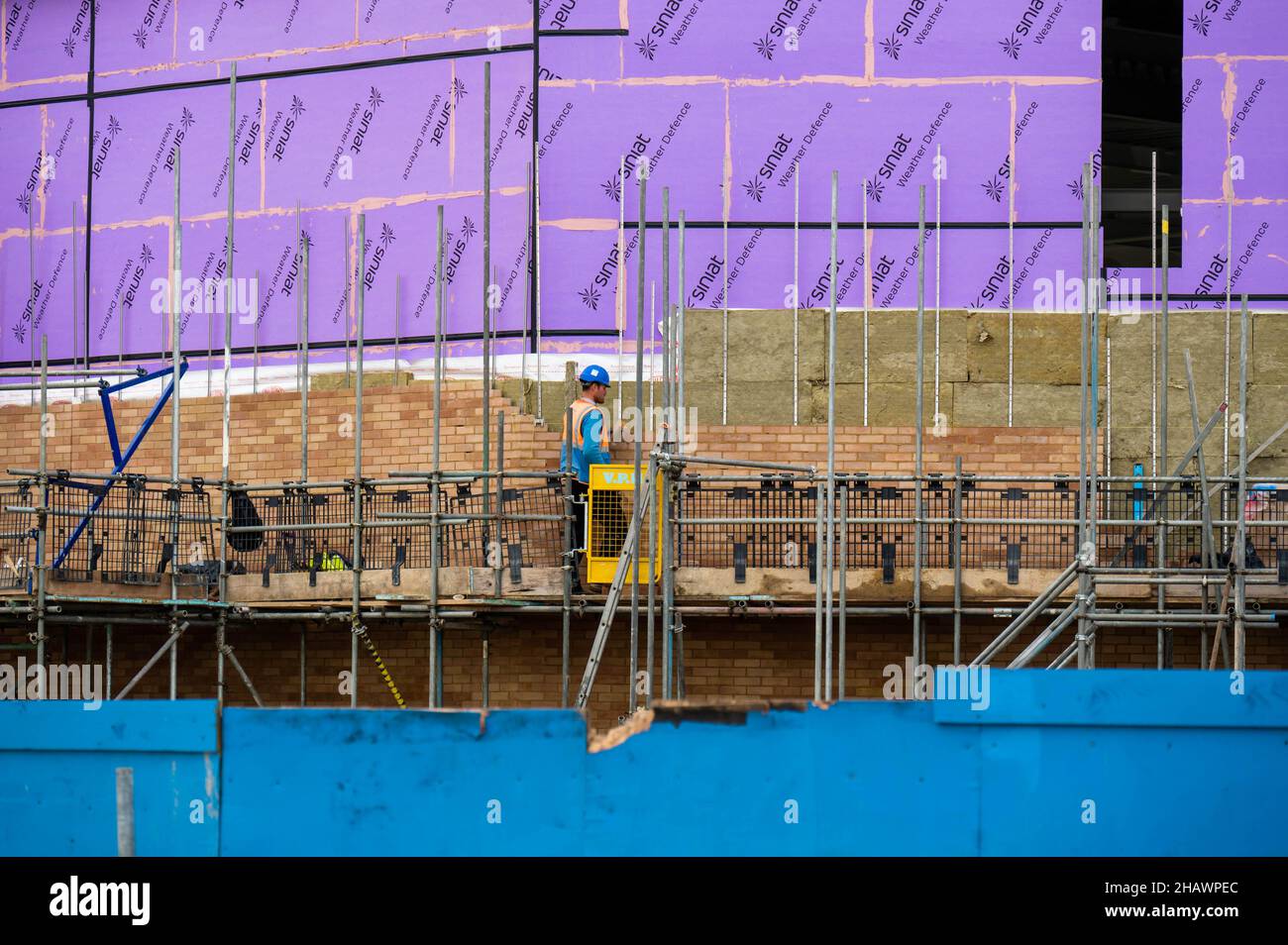 Maurer auf Gerüsten und Ziegelsteine auf dem Gebäude des neuen Marina-Teils, der an der Great Yarmouth-Küste gebaut wurde Stockfoto