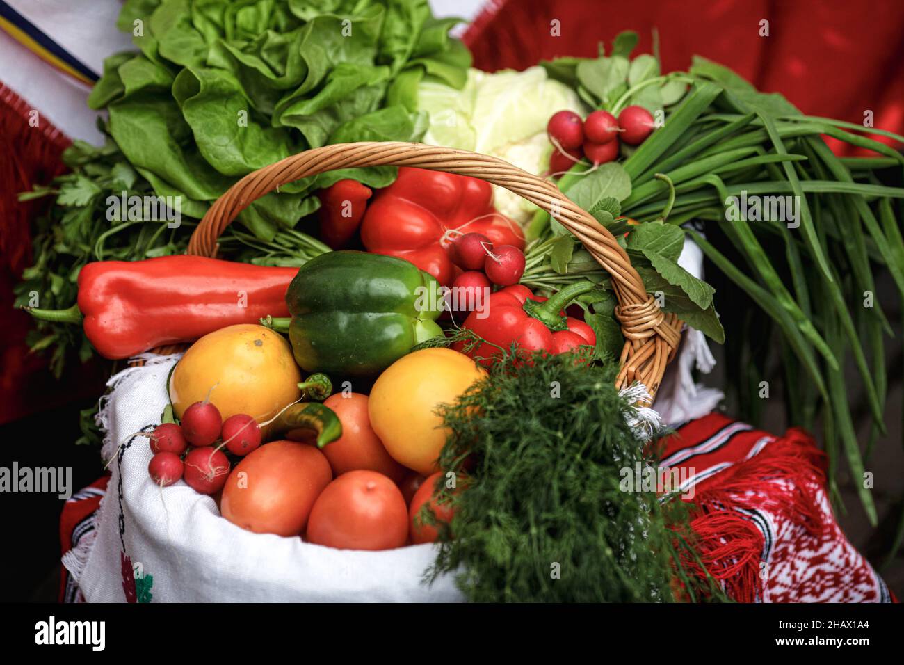 Bild mit geringer Schärfentiefe (selektiver Fokus) und einem Korb mit frischem Bio-Gemüse (roter Pfeffer, Rettich, Frühlingszwiebeln, Tomaten) zum Verkauf Stockfoto