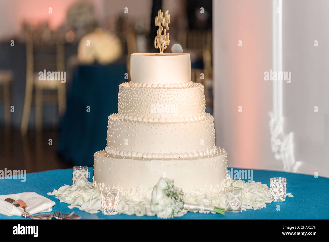 Weiße dreistufige Hochzeitstorte mit weißen Perlen und Blumen in aufrichtendem Stil Stockfoto