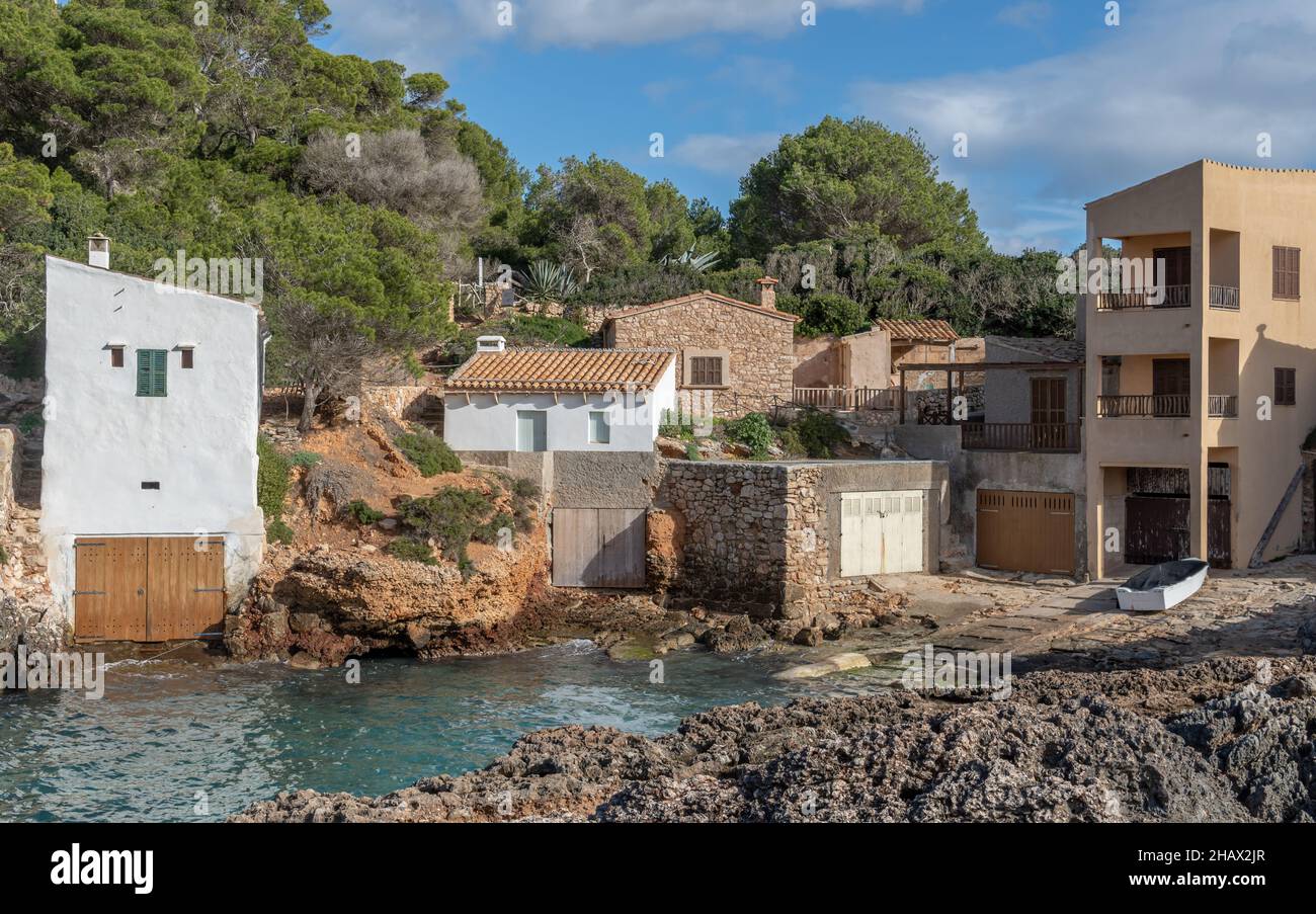 Landschaft der felsigen Küste der Insel Mallorca, mit einem Küstenfischendorf, einem bewölkten und sonnigen Wintertag. S'Almonia Bucht Stockfoto