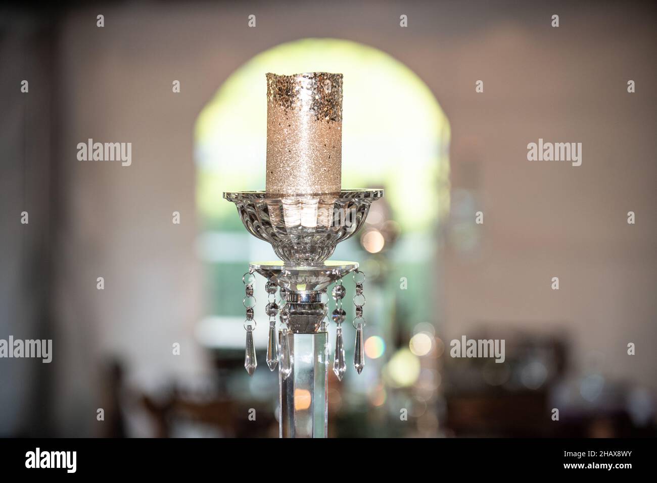 Kerzenhalter aus Kristallglas im Mittelpunkt mit goldener Kerze Stockfoto