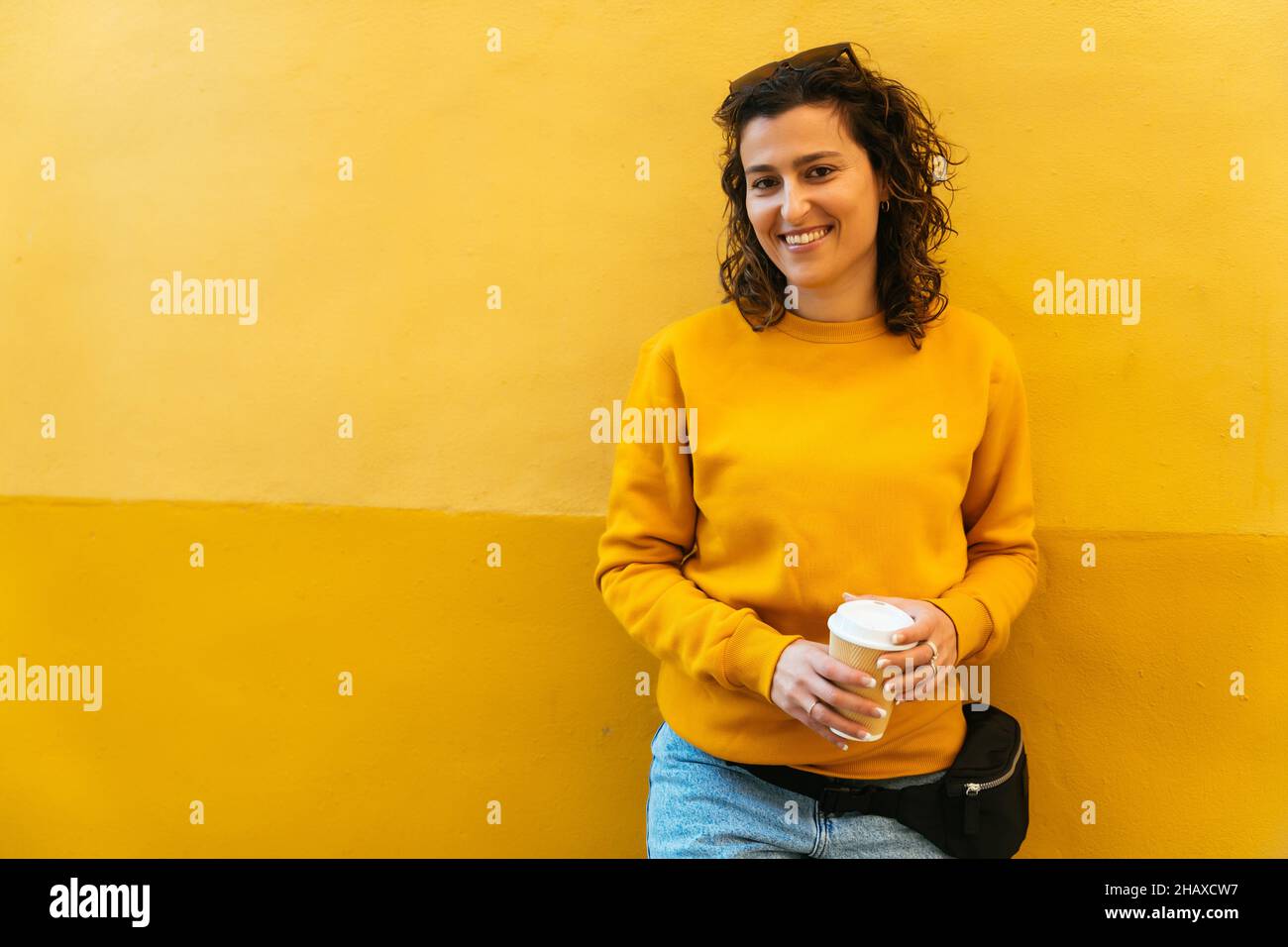 Fröhliche junge Frau mit einer Tasse Kaffee Stockfoto