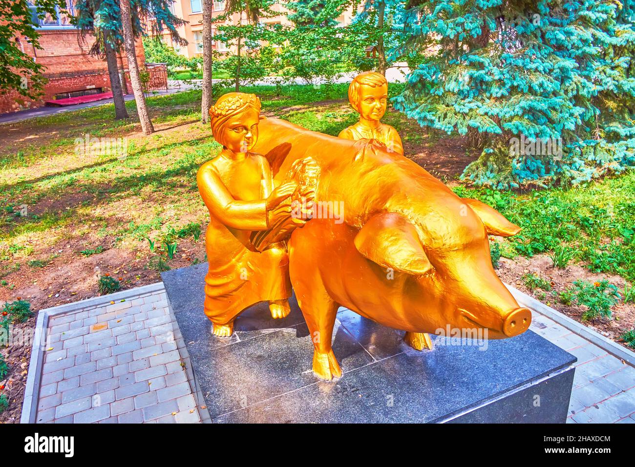 POLTAWA, UKRAINE - 22. AUGUST 2021: Die ungewöhnliche goldene Skulptur für ein Schwein und Kinder, auf dem Territorium der Landwirtschaftlichen Universität, am 22. August Stockfoto