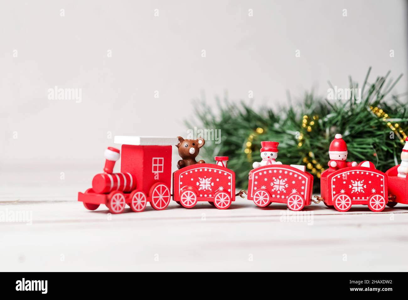 Das Konzept des kommenden neuen Jahres, Weihnachten. Der rote Neujahrszug mit einem grünen Ast auf weißem Hintergrund. Stockfoto