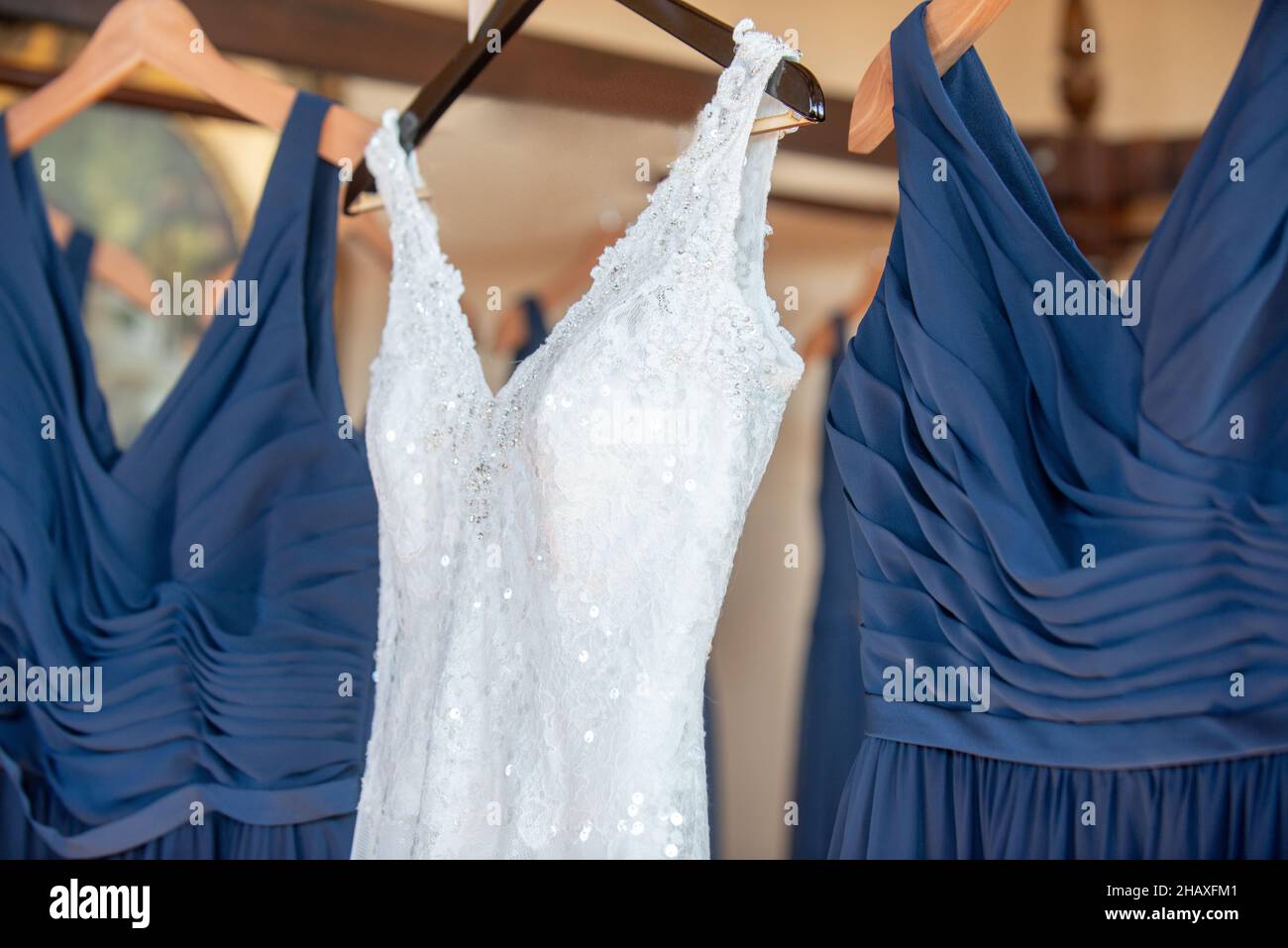 Wunderschöne weiße Bräute Kleid hängen von Bettgestell mit blauen Brautjungfern Kleider Stockfoto