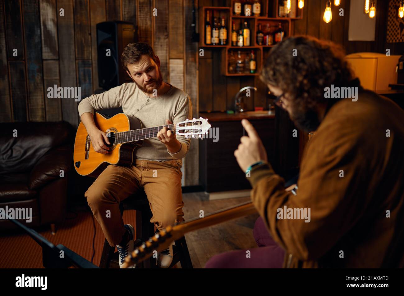 Musiklehrer beim Melodiespielen auf der E-Gitarre Stockfoto