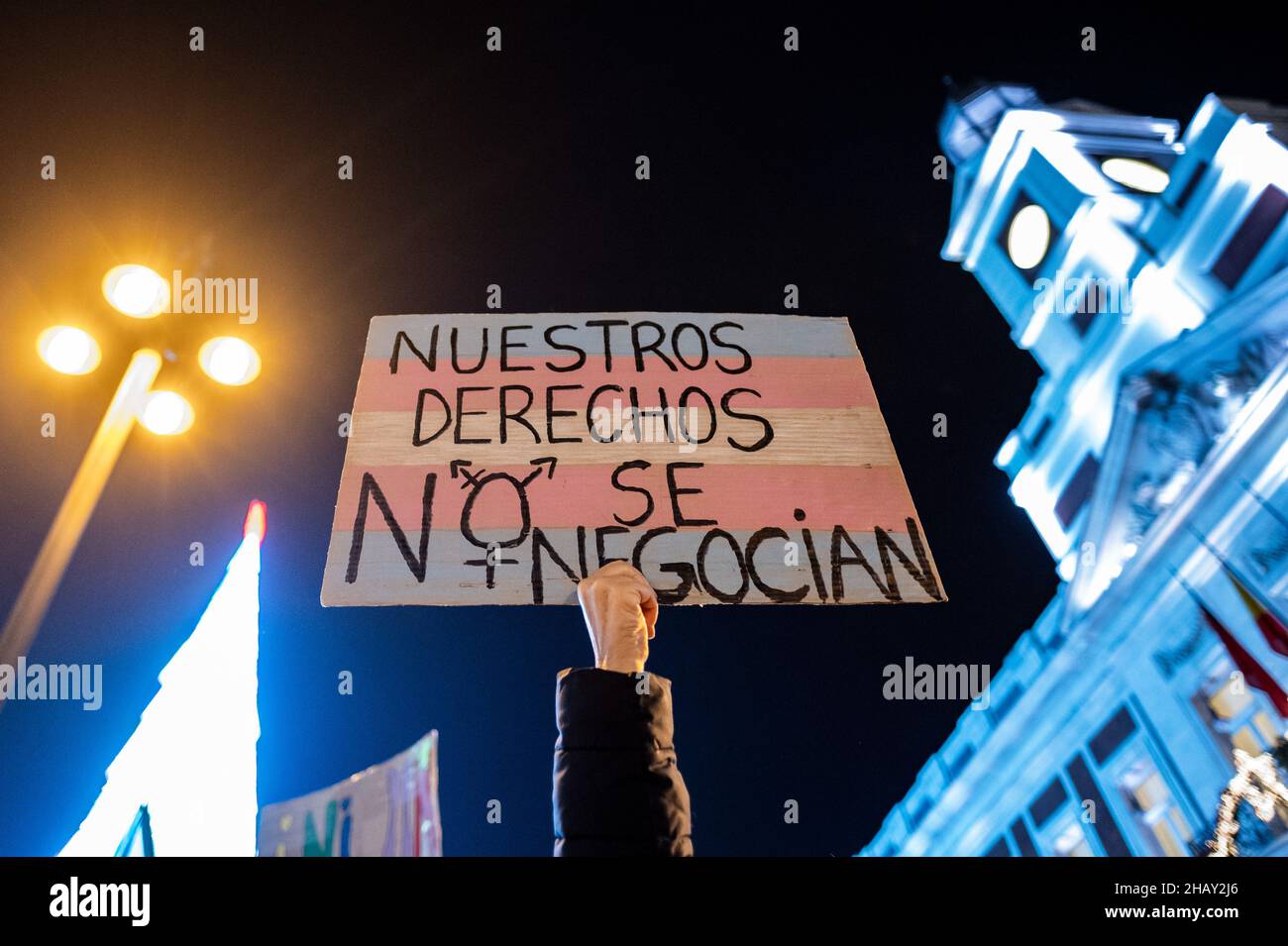 Madrid, Spanien. 15th Dez 2021. Die Hand einer Frau hält ein Plakat mit der Transgender-Flagge mit der Aufschrift "Unsere Rechte werden nicht verhandelt", als sich Menschen an der Puerta del Sol während eines Protestes zur Verteidigung der Rechte des LGTBI-Kollektivs versammelten. Der Protest wurde organisiert, als bekannt wurde, dass der Vorschlag für das Gleichstellungsgesetz der rechtsextremen Partei VOX in einer ihrer Sektionen die Aufhebung der beiden Gesetze beinhaltete, die dieses Kollektiv bereits schützen und die am 16. Dezember auf der Madrider Versammlung abgestimmt werden. Quelle: Marcos del Mazo/Alamy Live News Stockfoto