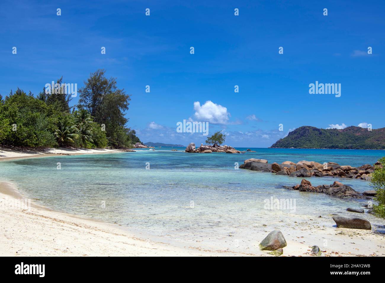 Felsige Küste mit kleiner Bucht und Insel Anse Takamaka Praslin Insel Seychellen Stockfoto