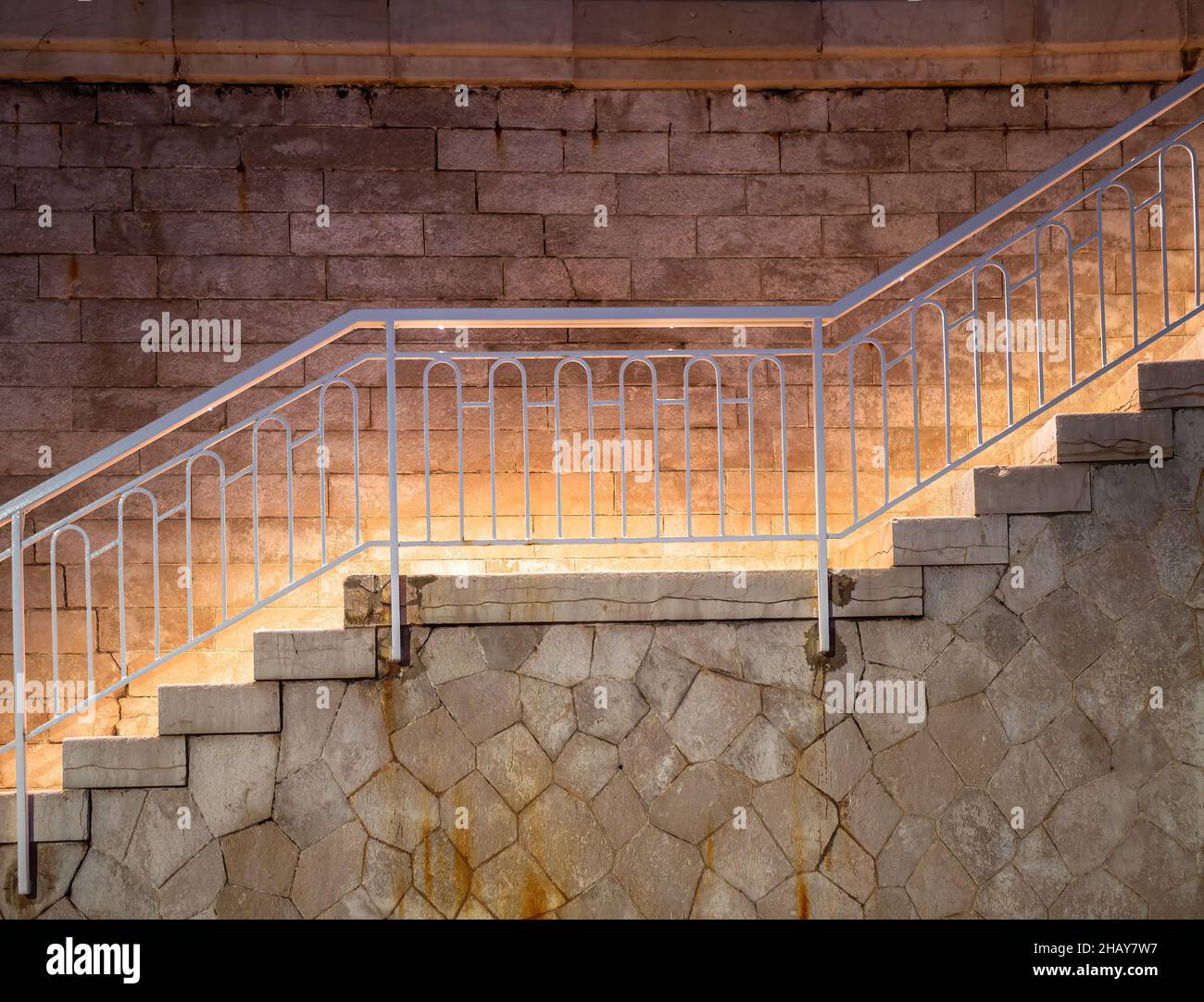 Beleuchtete historische Treppe bei Nacht auf den Hafenmauern der mediterranen französischen Stadt Menton Stockfoto