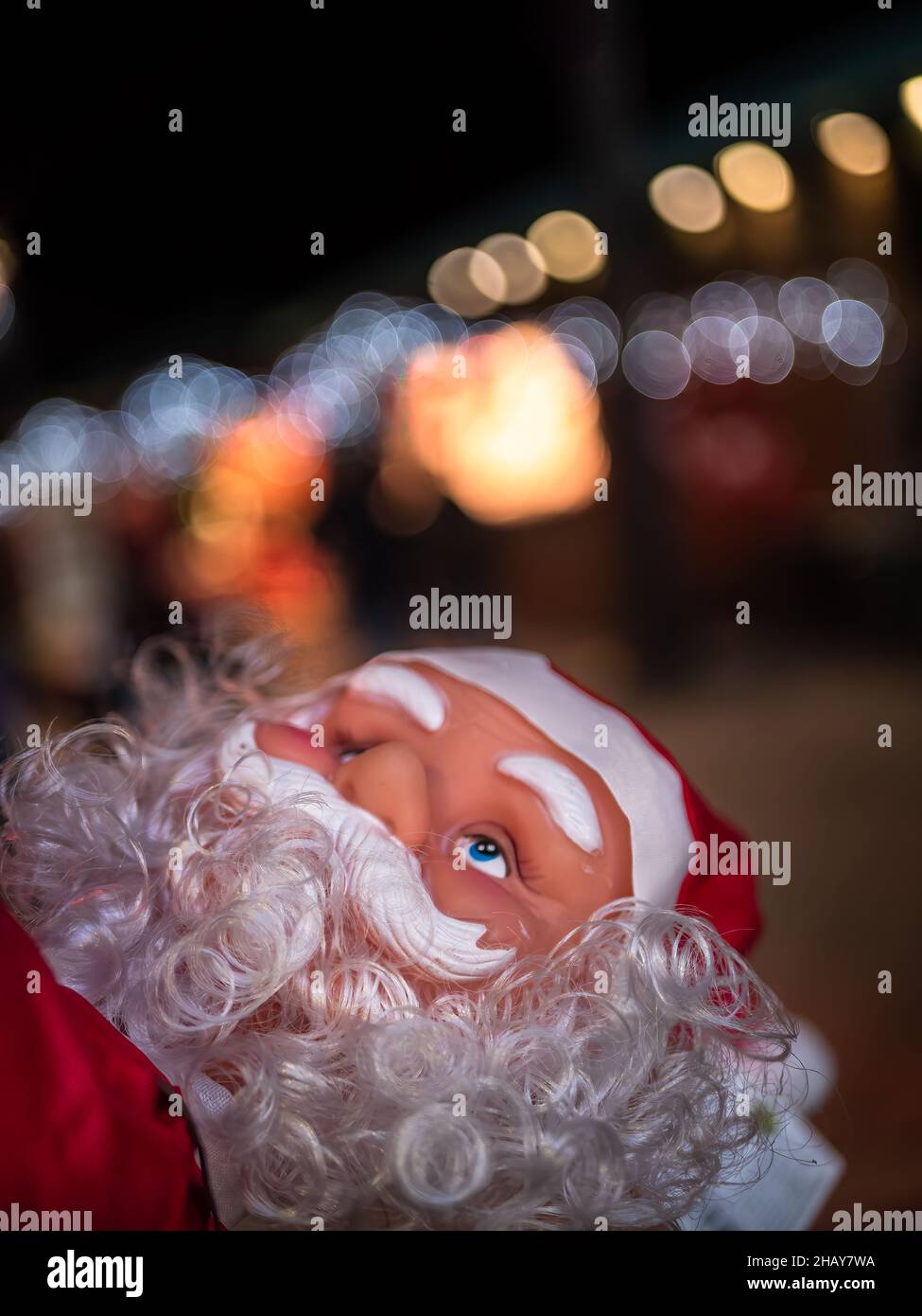 Das Gesicht des Weihnachtsmannes und die Bokeh-Lichter der Weihnachtsbeleuchtung Stockfoto
