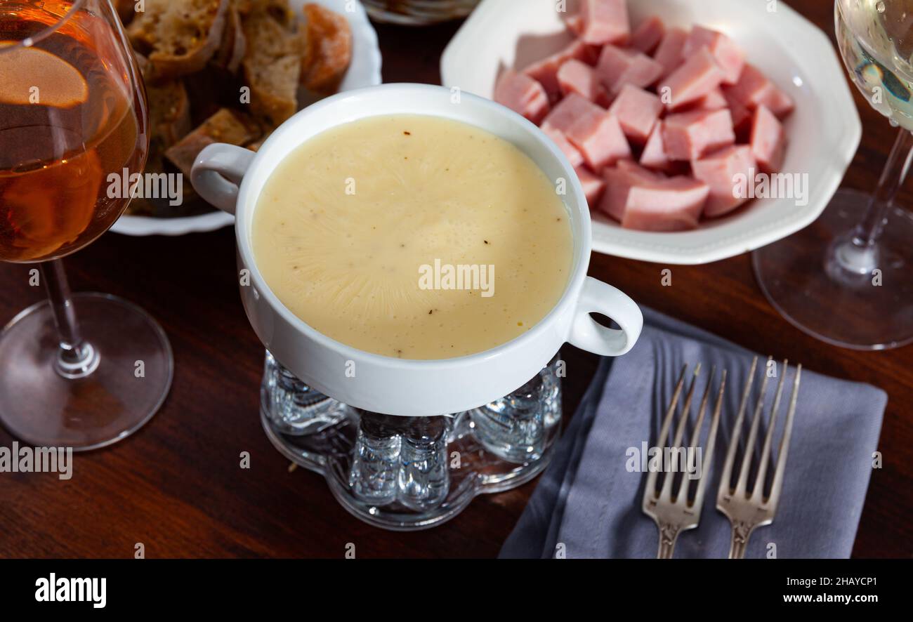 Abendessen mit Käsefondue, Würstchen und Brot Stockfoto