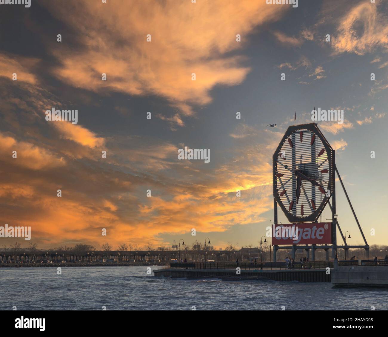 Große Uhr und ein Colgate-Schild am Ufer des Flusses in New York während des Sonnenuntergangs Stockfoto