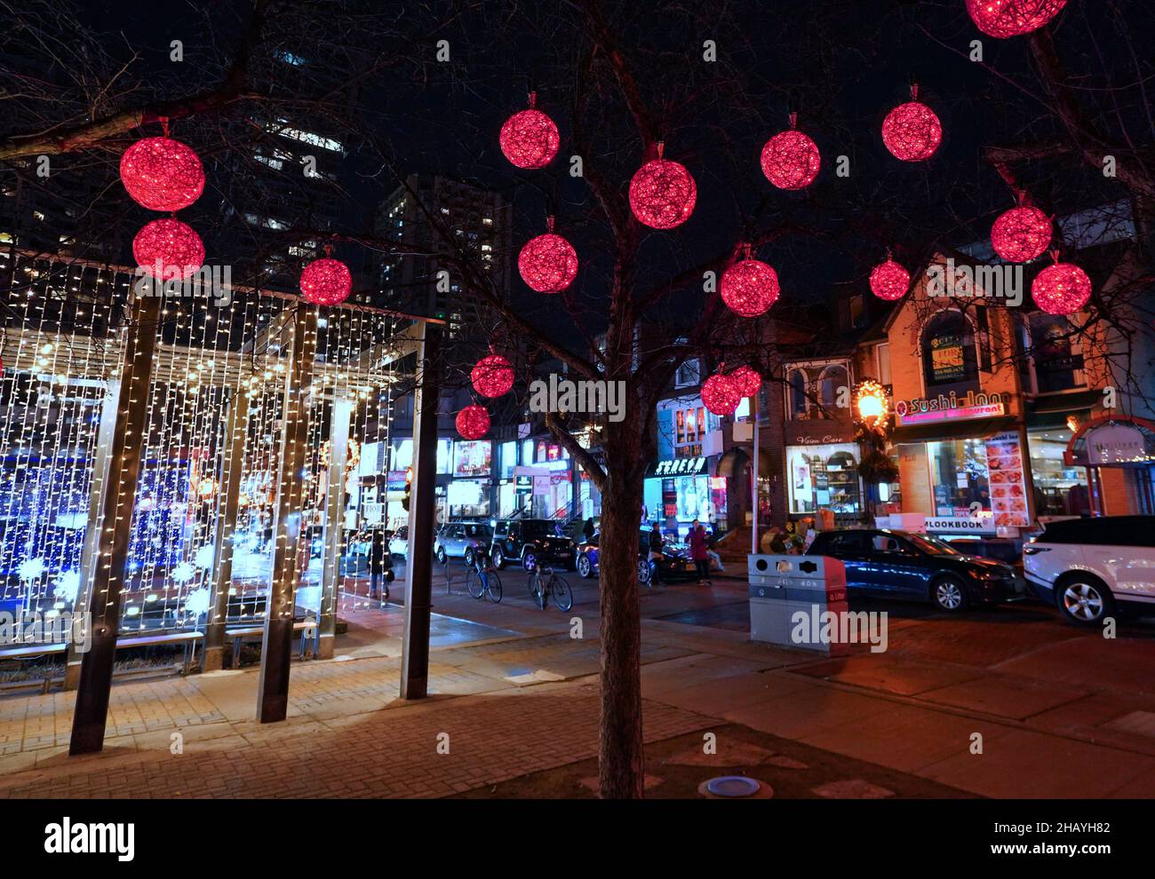 Toronto, Kanada - 14. Dezember 2021: Das Einkaufsviertel von Yorkville wird von einem bunten Lichtermeer auf der Straße belebt. Stockfoto