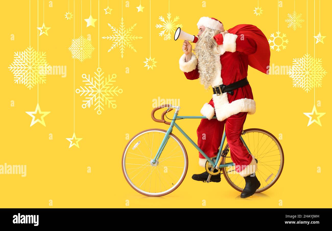 Weihnachtsmann mit Megaphon, Tasche und Fahrrad auf gelbem Hintergrund Stockfoto